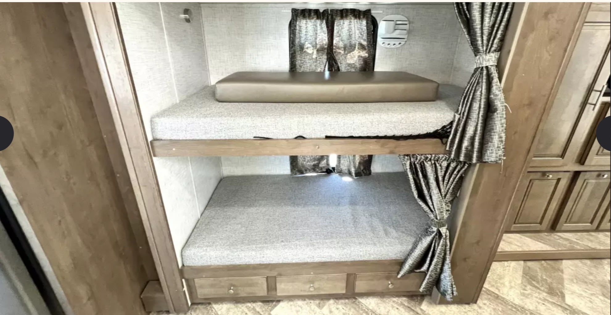 Inside this RV rental, comfortable bunk beds offer a dedicated sleeping area. Features include curtains, a top cushion, and bottom storage drawers.. Forest River Other 2021