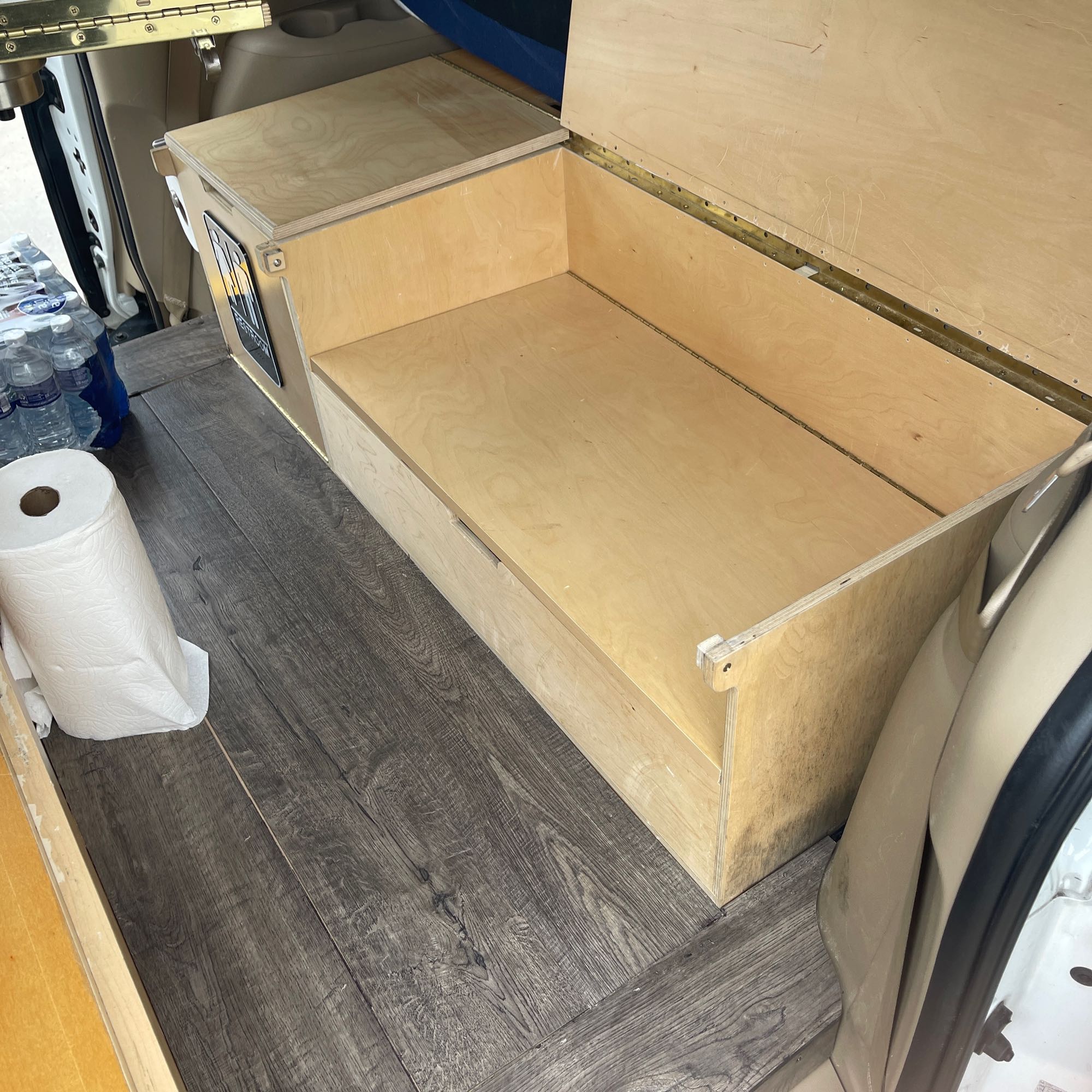 Inside an RV rental: a custom wooden storage bench with hinged access, perfect for camper organization. Features a laminate floor.. Hobby Vantana 65E 2007