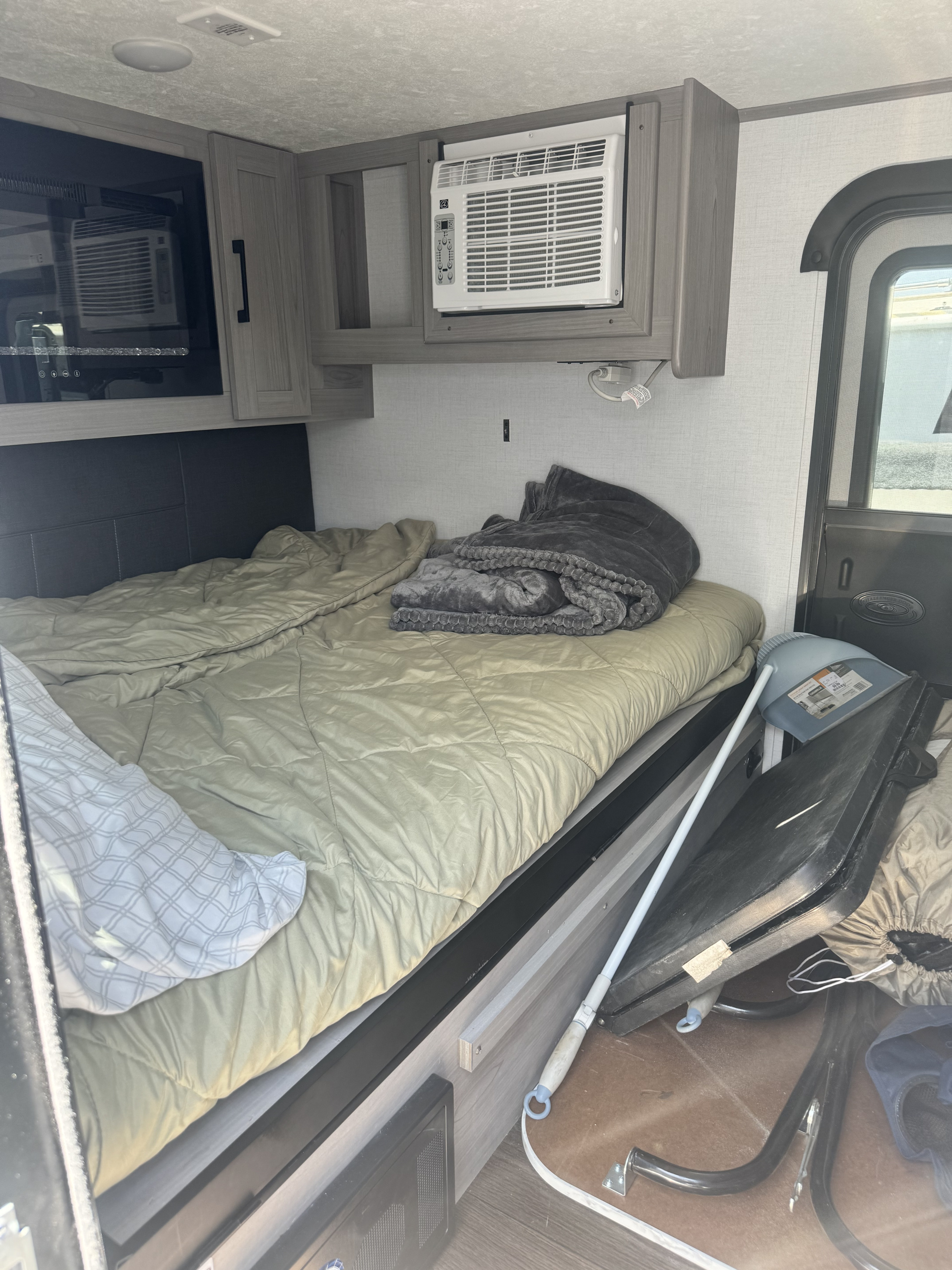 Inside an RV rental: a comfortable bed with AC and microwave overhead, plus storage. Ready for travel.. Rubicon 4YDTCHME10RJ933964 2024