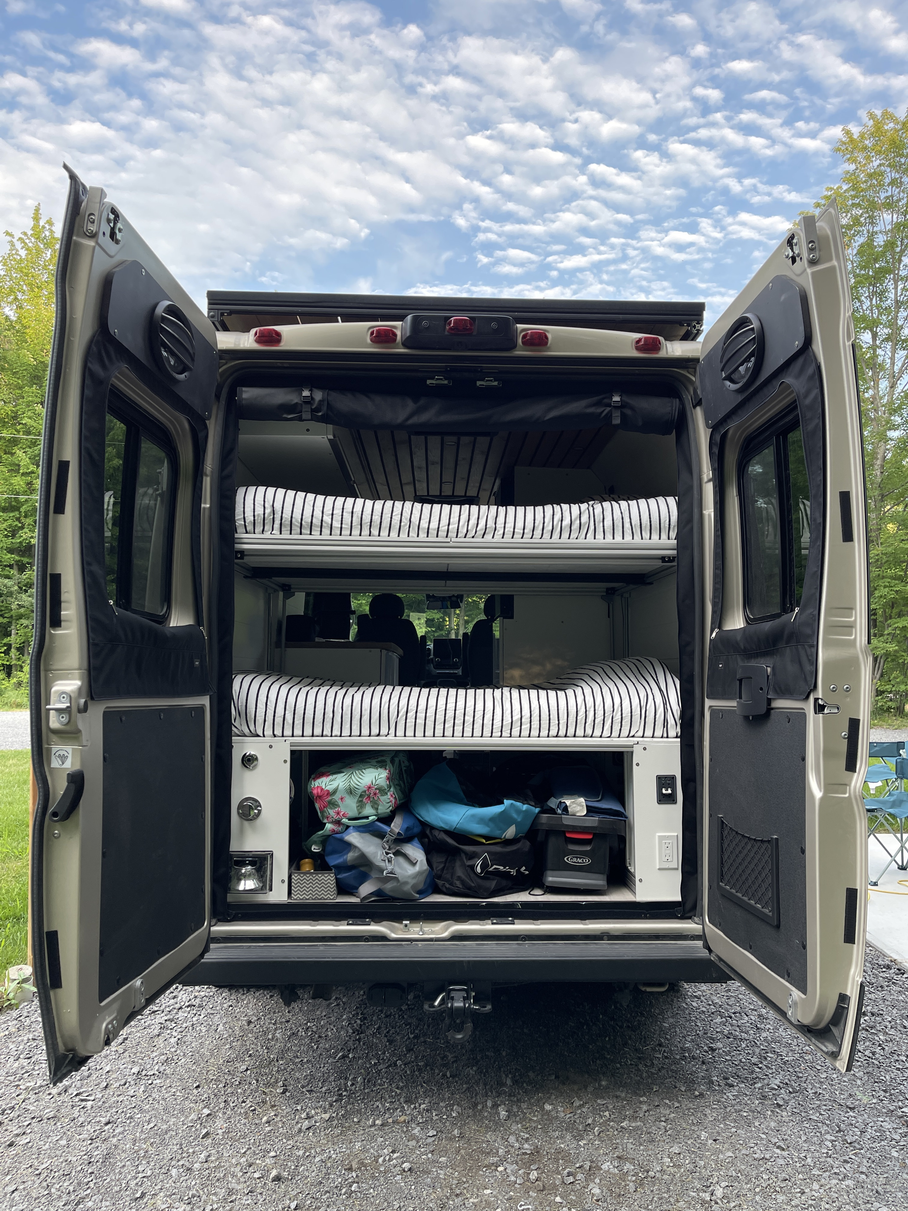 Rear view of a spacious RV rental interior, showcasing bunk beds and ample storage for your journey.. Ram Promaster 3500 2023