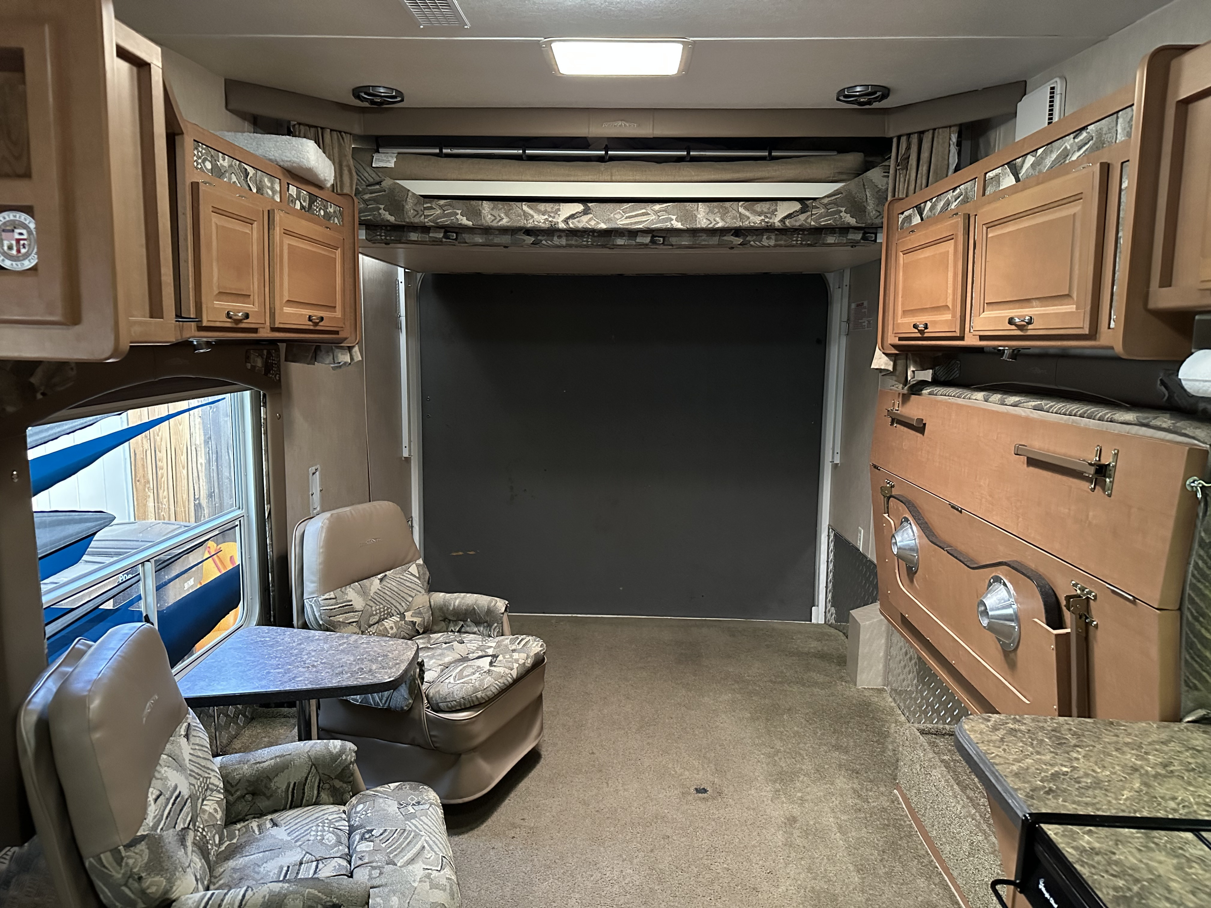 Explore this RV rental toy hauler interior with comfortable seating, overhead cabinets, and a rear garage for gear.. Weekend Warrior Widelite Wlfs 2600 2008