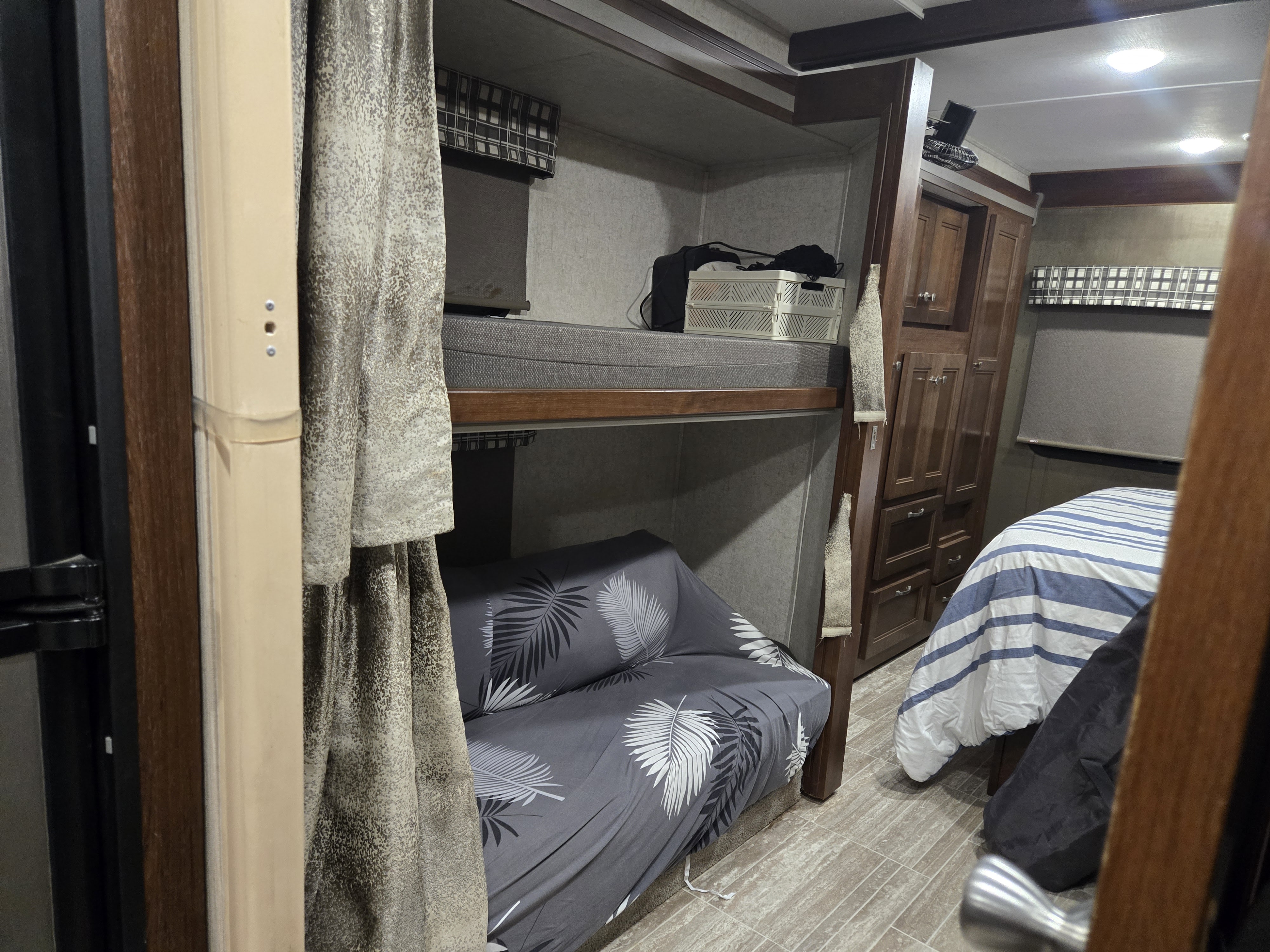 An RV rental's versatile interior: bunk beds, sleeper sofa, and master bed, optimized for compact travel.. Forest River Sunseeker LE 2020