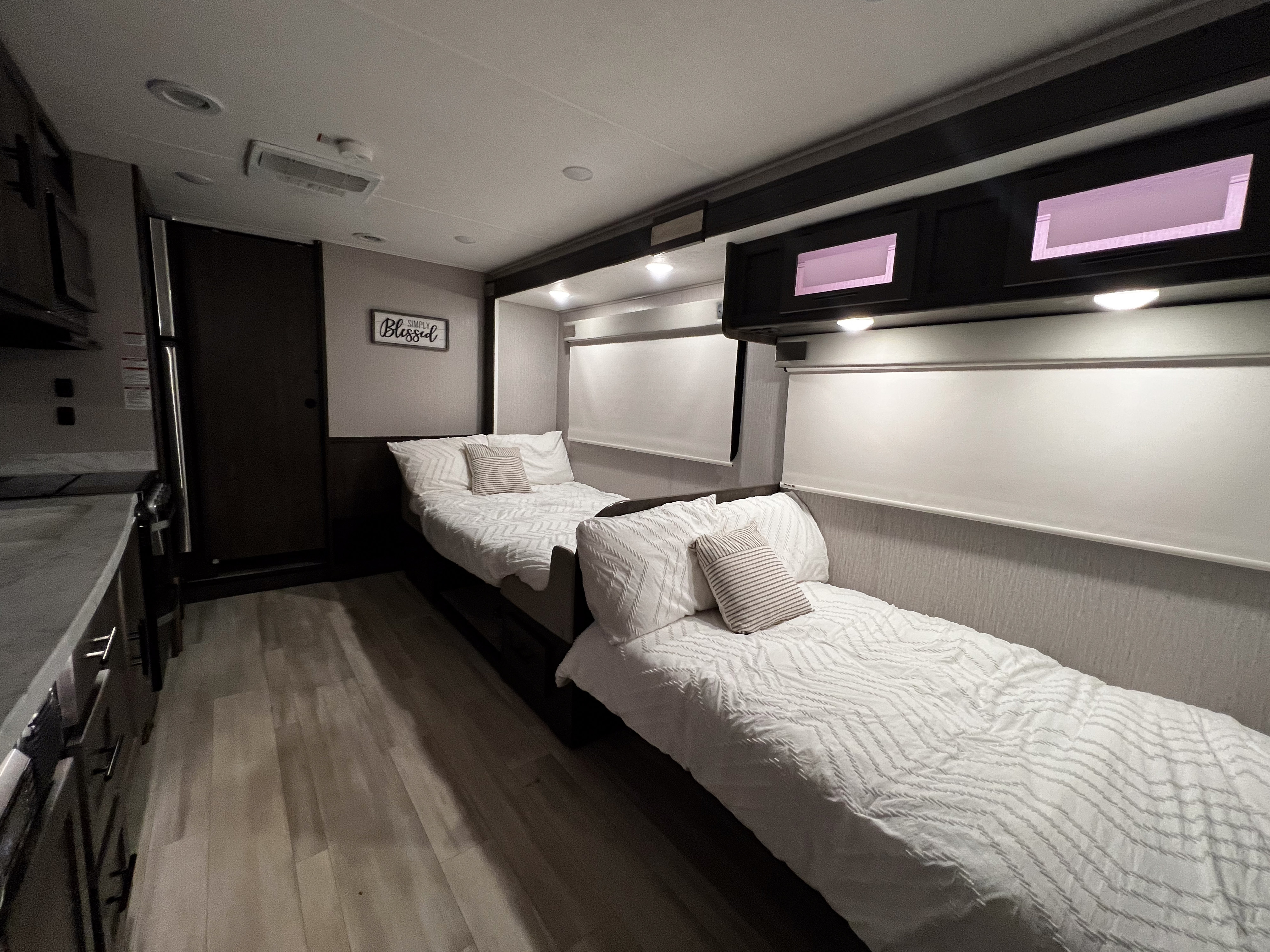 This RV rental's cozy interior features two neatly made single beds, overhead cabinets, and blinds.. Coachmen Leprechaun 2022