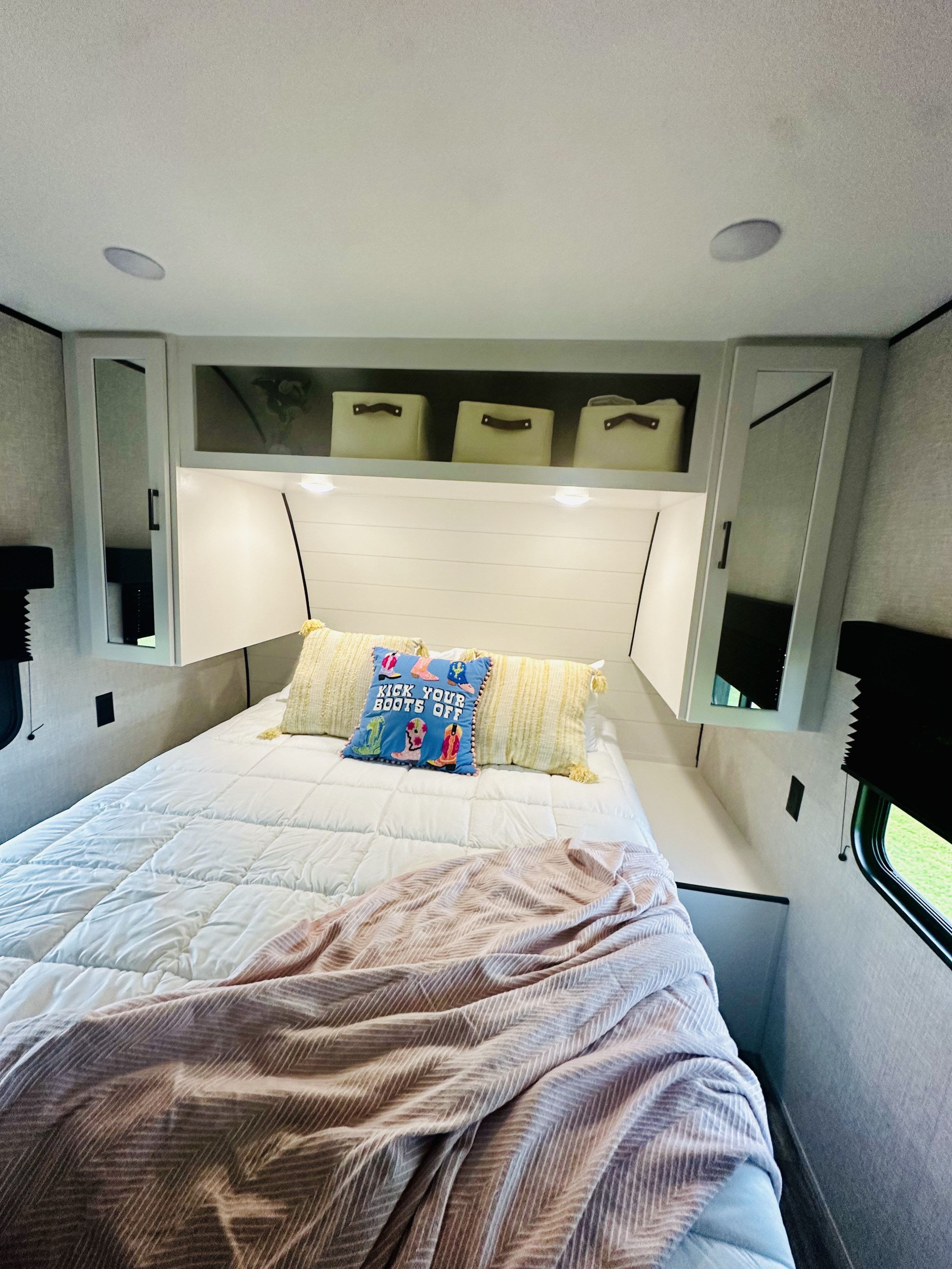 Cozy RV rental bedroom with a comfy bed, accent pillows, practical overhead storage, and a window.. JAYCO JAY FLIGHT 260BH 2025