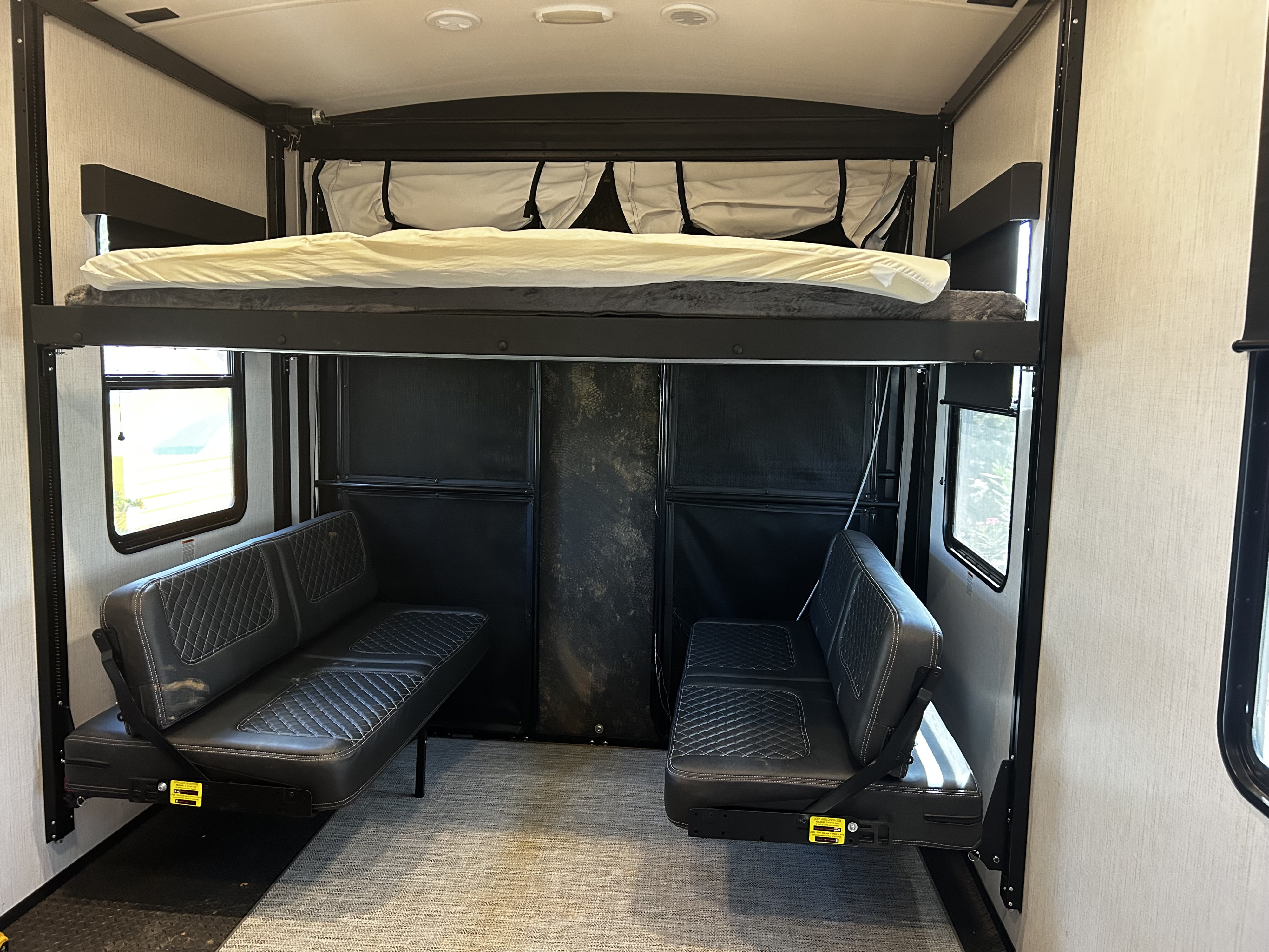 RV rental: Spacious toy hauler interior with a bunk bed, fold-down sofas, and durable flooring, ready for adventure.. R V C Stryker 2022