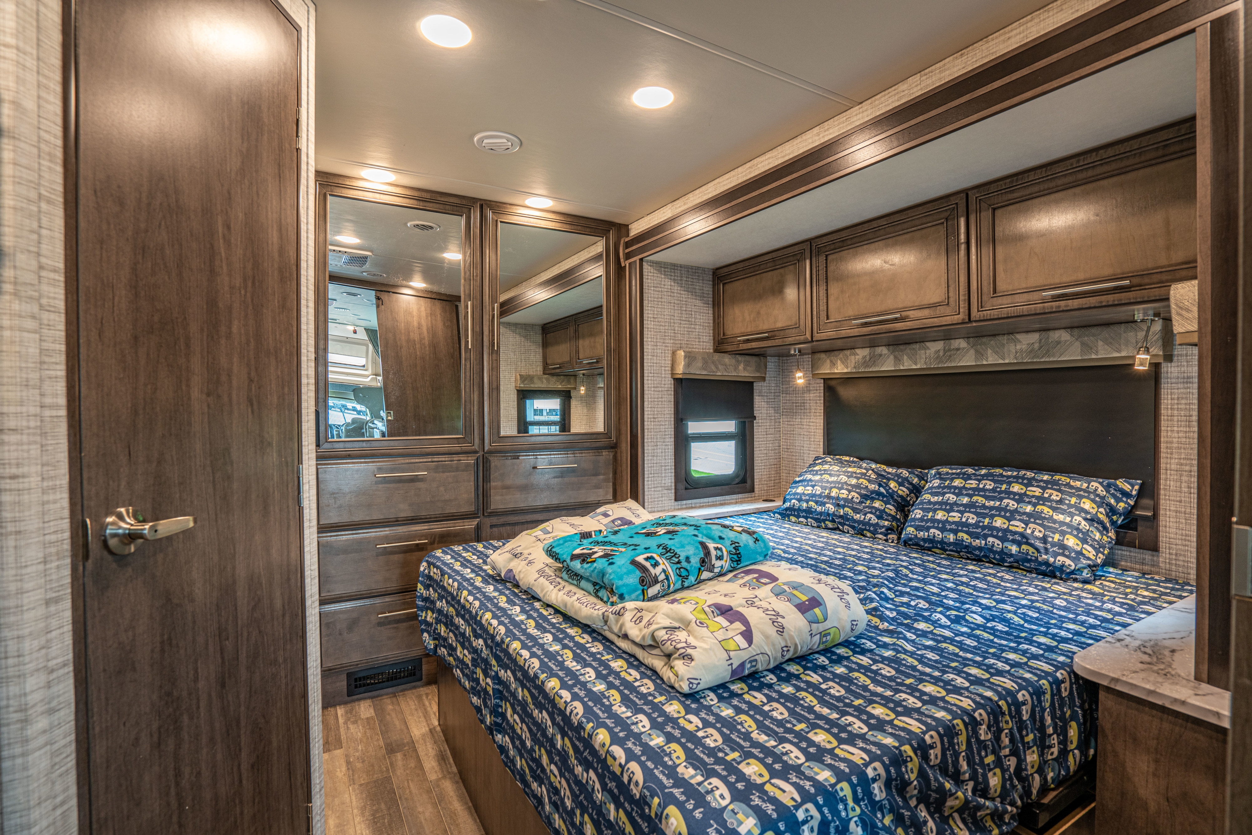 Explore the cozy bedroom of this RV rental, featuring themed bedding, built-in storage, and ambient lighting.. Entegra Coach Esteem 2024