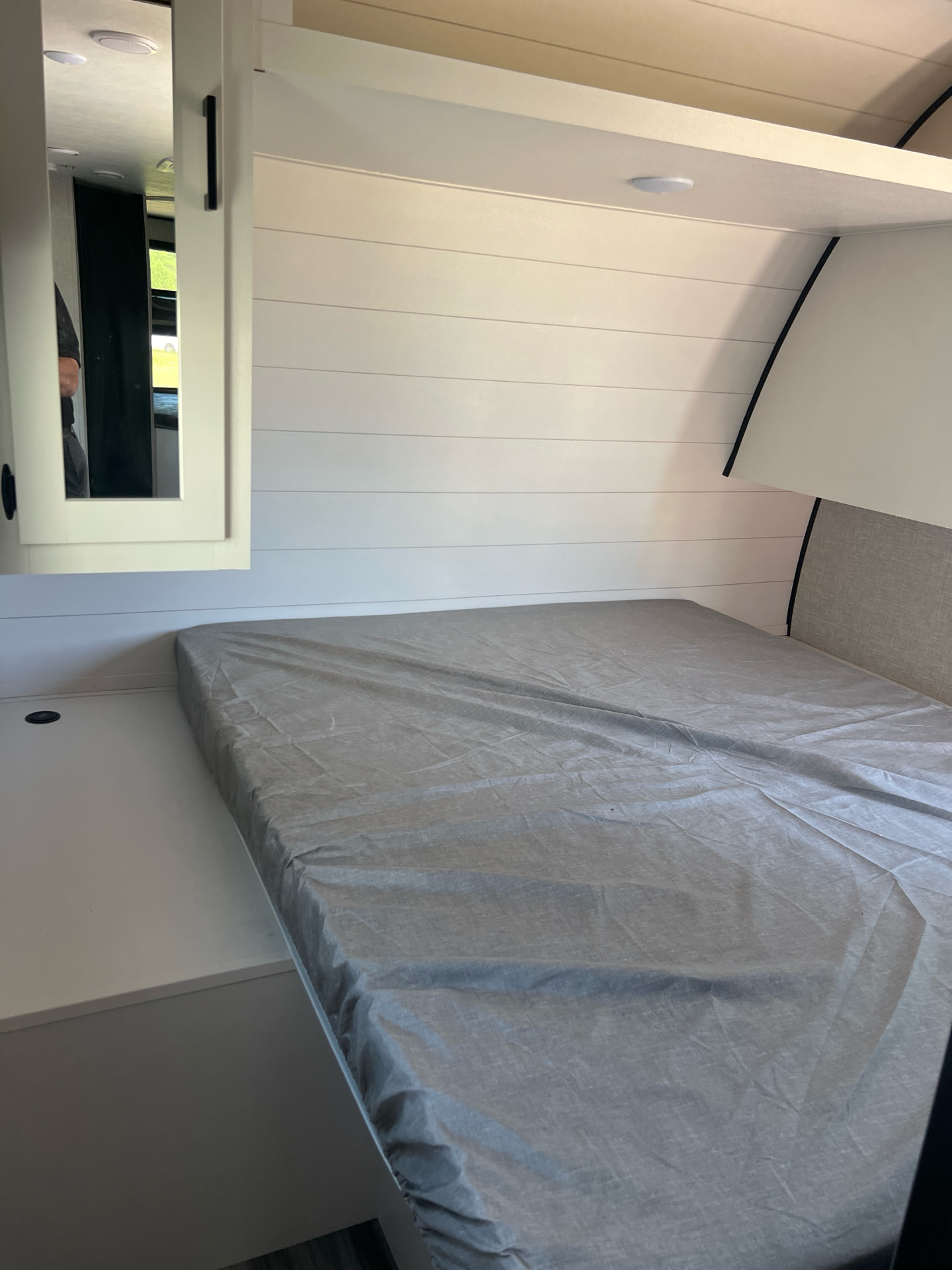 Cozy RV rental bedroom with shiplap walls, comfortable bed, and mirror cabinet for your road trips.. Starcraft Autumn Ridge 2024