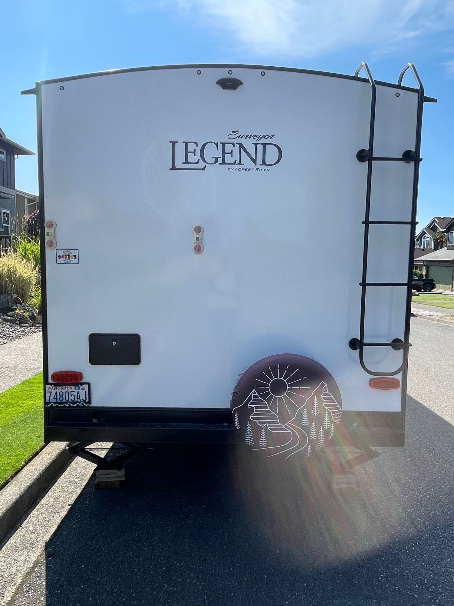 White travel trailer rear view: ladder, spare tire cover, WA plate. Your next rv rental adventure awaits!. Forest River Surveyor Legend 2021