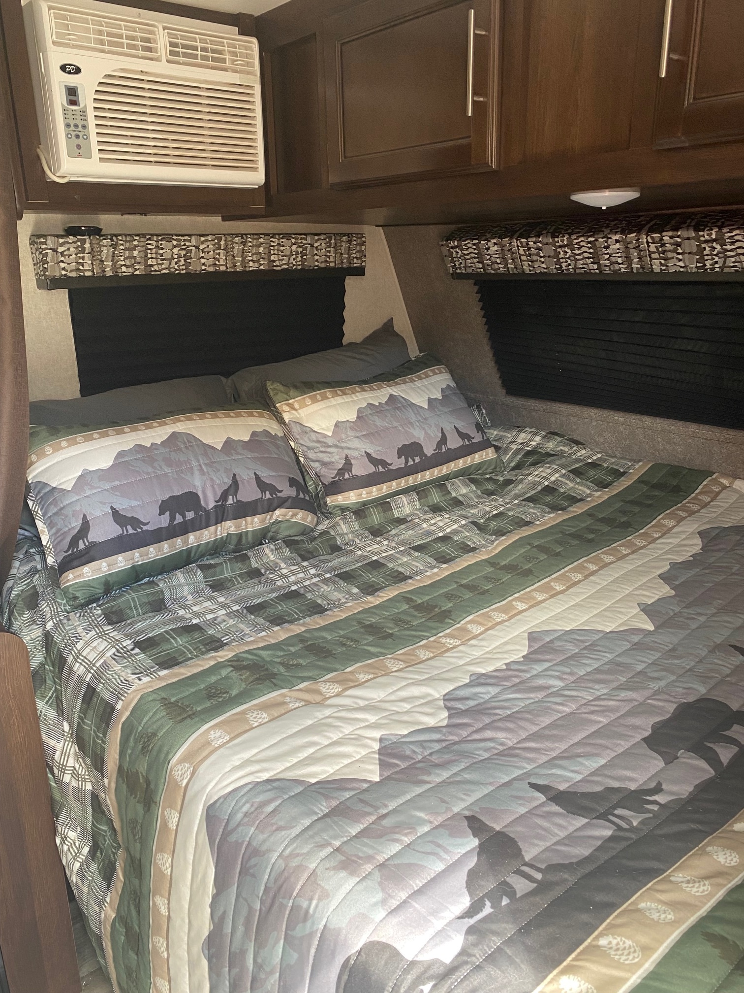 Explore this cozy RV rental bedroom, featuring nature-themed bedding with bears & wolves, an AC, and storage cabinets.. Jayco Jay Flight SLX 2019