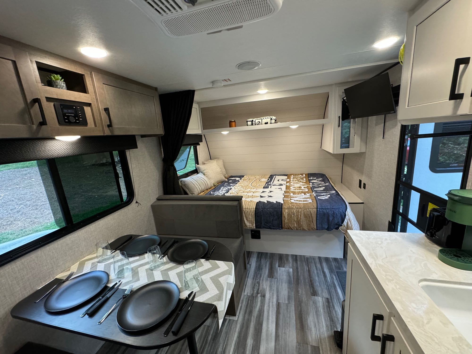Modern rv rental interior showcasing a compact kitchen, inviting bed, and ready-to-use dining area for your travels.. Jayco Free Flight SLX 2025