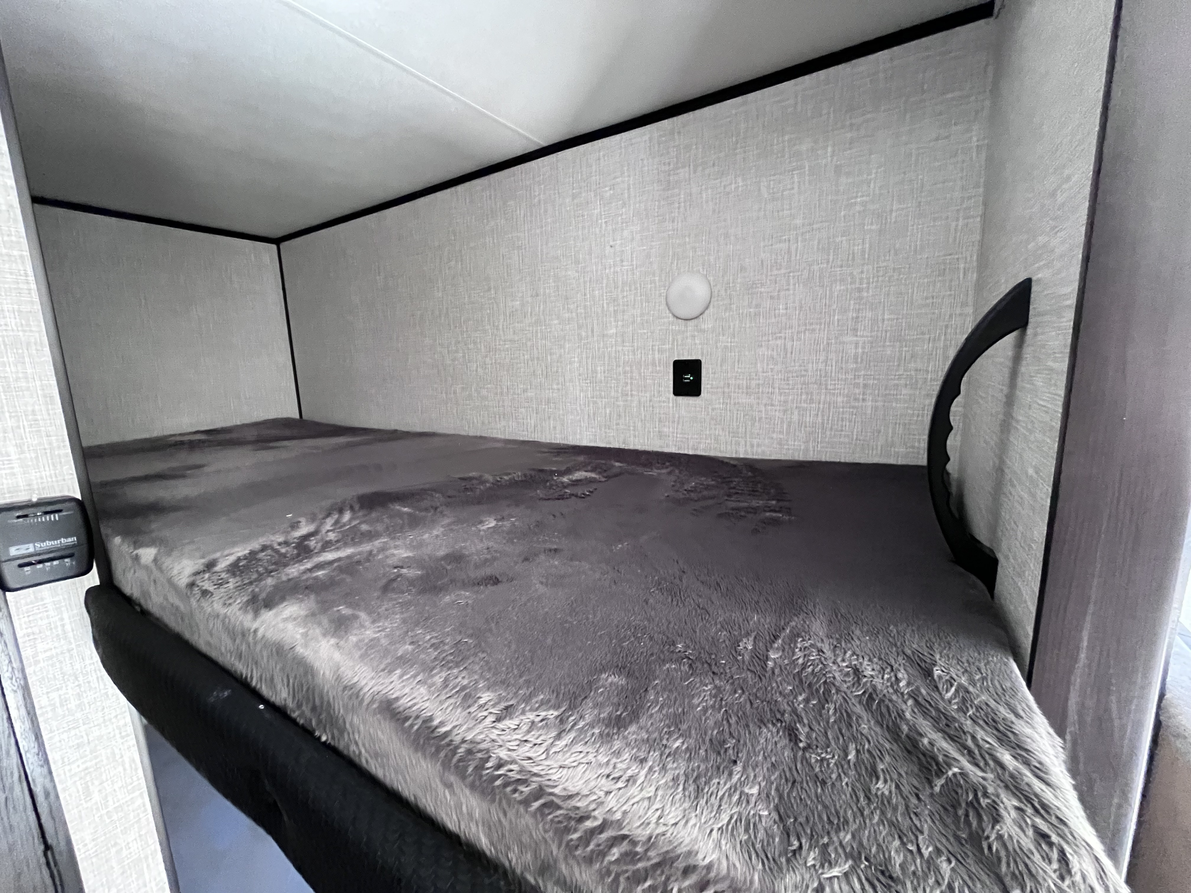 Inside an RV rental: a cozy bunk bed with soft grey bedding, lighting, and a charging station. Ideal for camping trips.. JAYCO Flight SLX 184BSW BAJA 2024