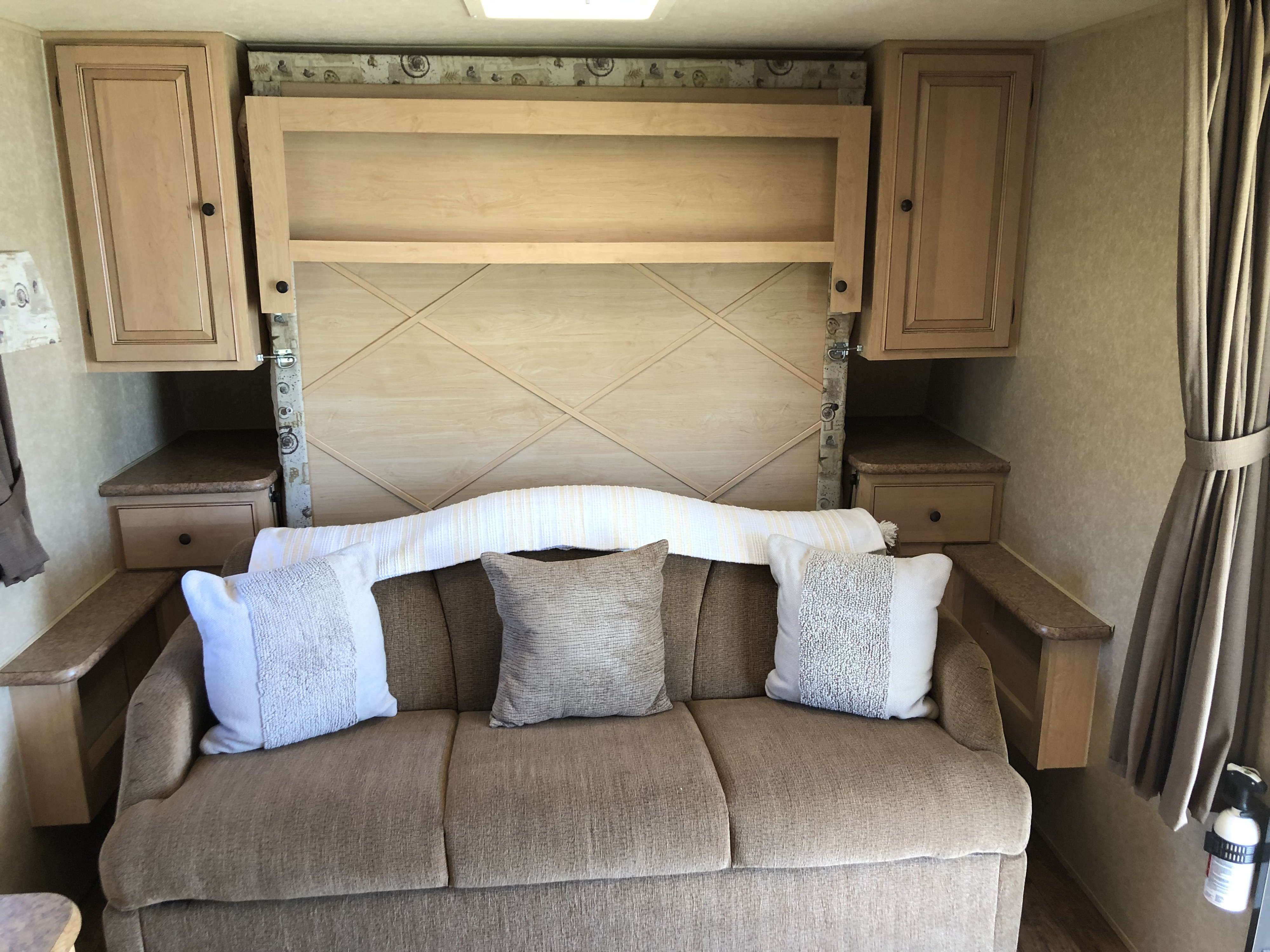 RV rental: Comfortable interior with sofa, side cabinets, and a cleverly concealed wall bed, ready for your trip.. Forest River Rockwood Mini Lite 2012