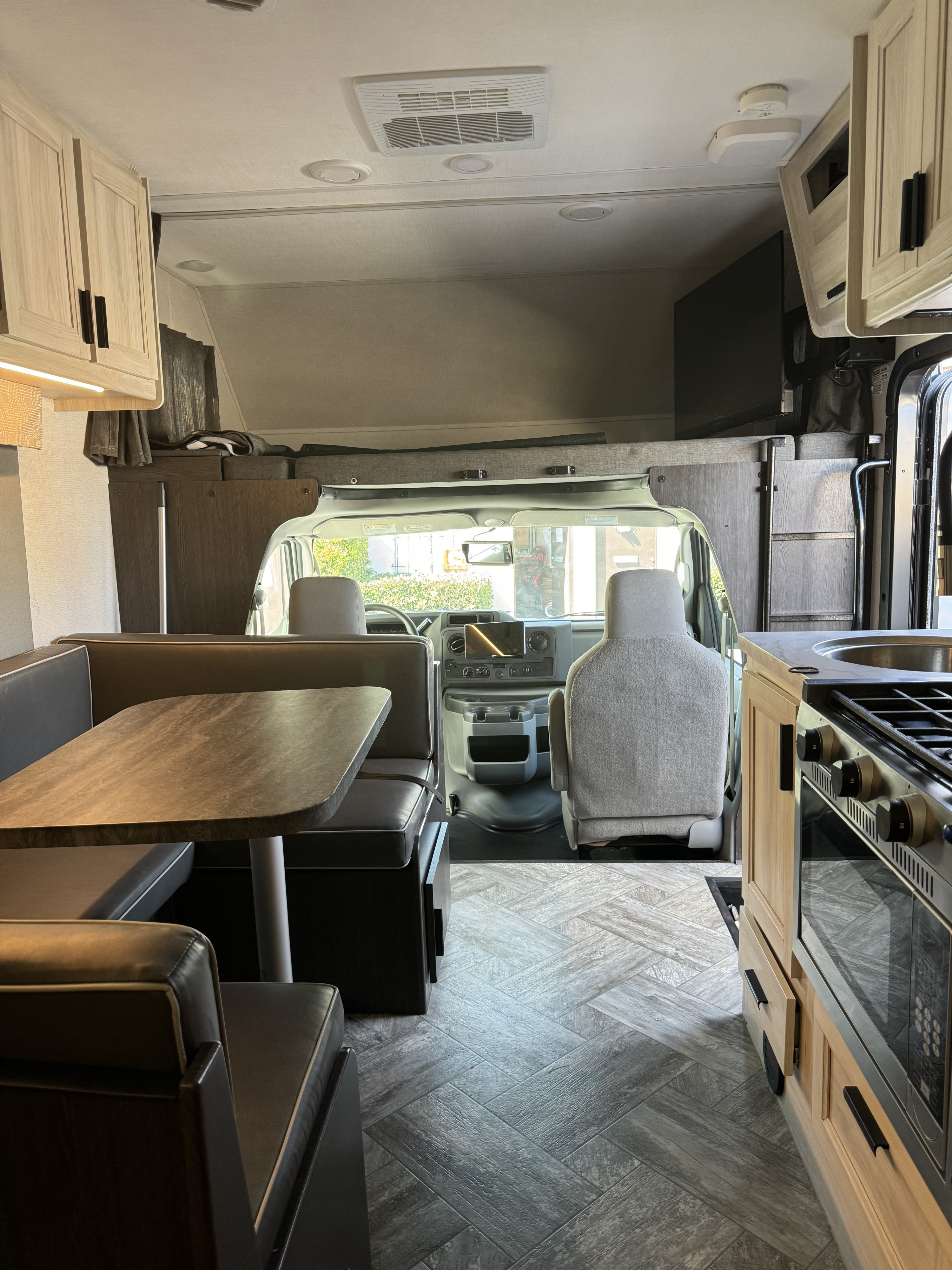 Spacious RV rental interior featuring a dinette, kitchen, and overhead bunk, perfect for your next road trip.. Forest River Sunseeker LE 2023