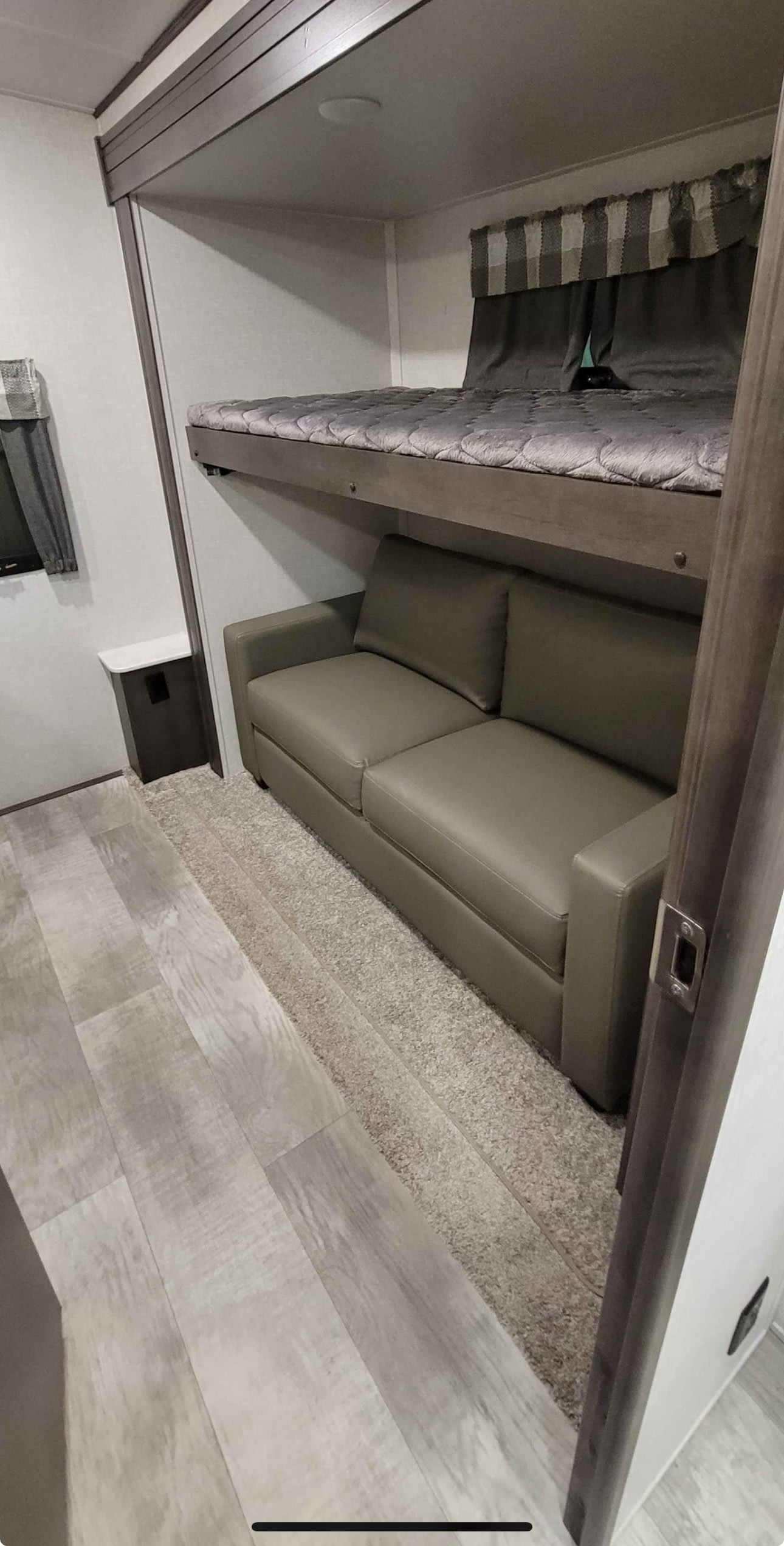Modern RV rental interior: a cozy bunk bed over a sleek sofa, optimized for compact living and travel.. Forest River Flagstaff Classic 2021
