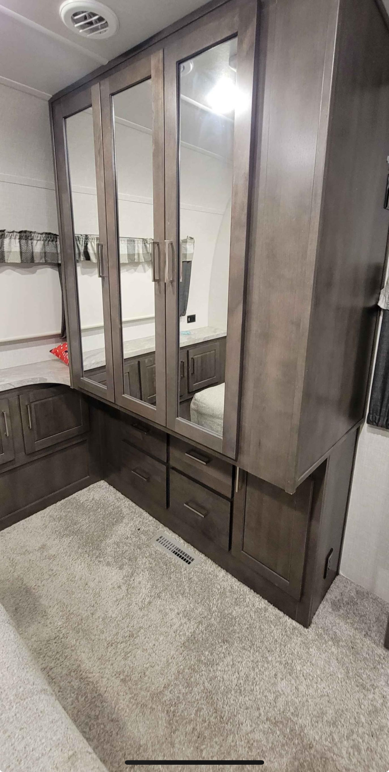 Spacious RV rental bedroom featuring mirrored wardrobe, ample storage, and cozy carpet.. Forest River Flagstaff Classic 2021