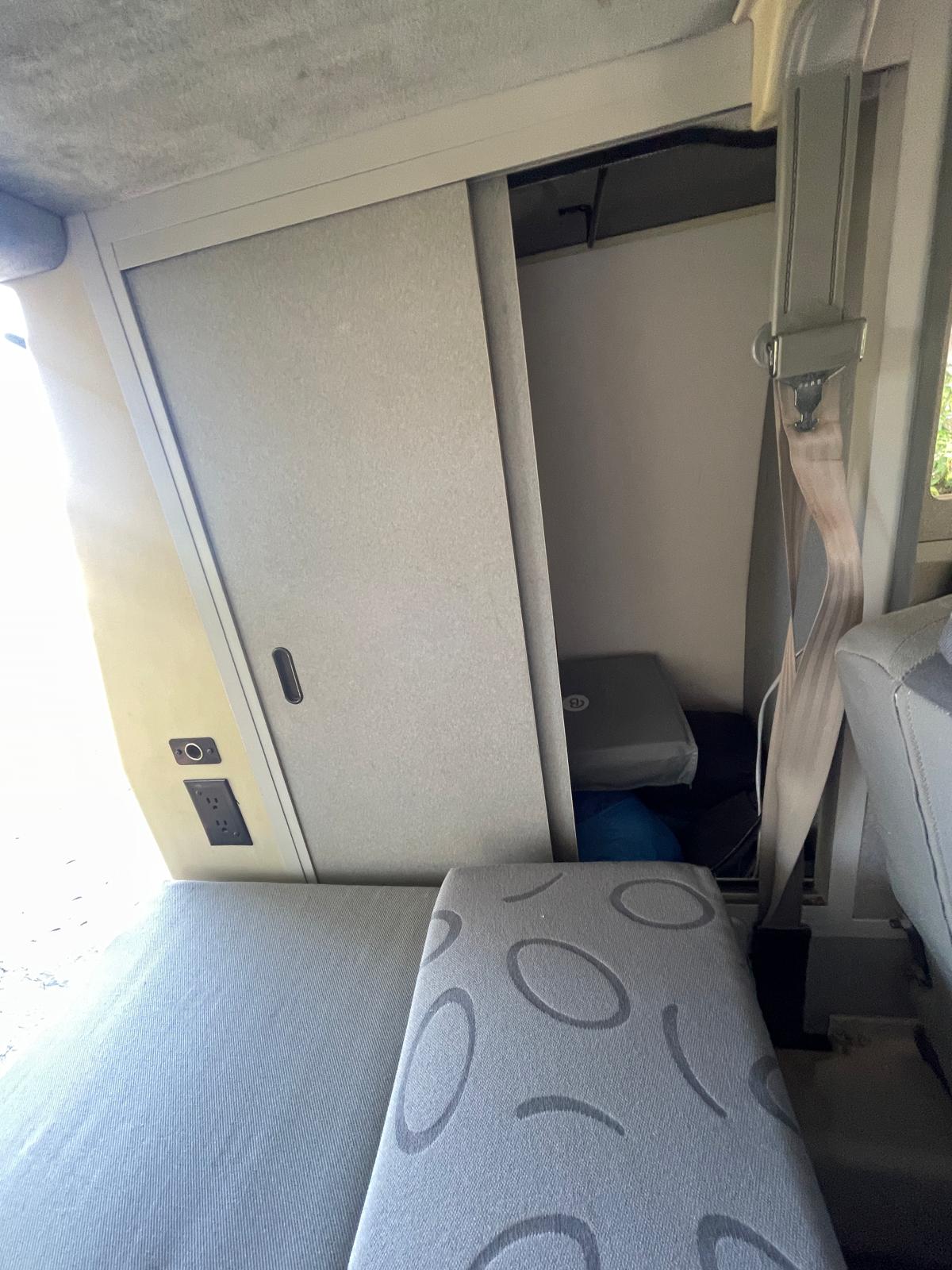 RV rental: view of a clever interior with a sliding storage door, power outlets, and patterned seating for comfort.. Volkswagen Eurovan 1999