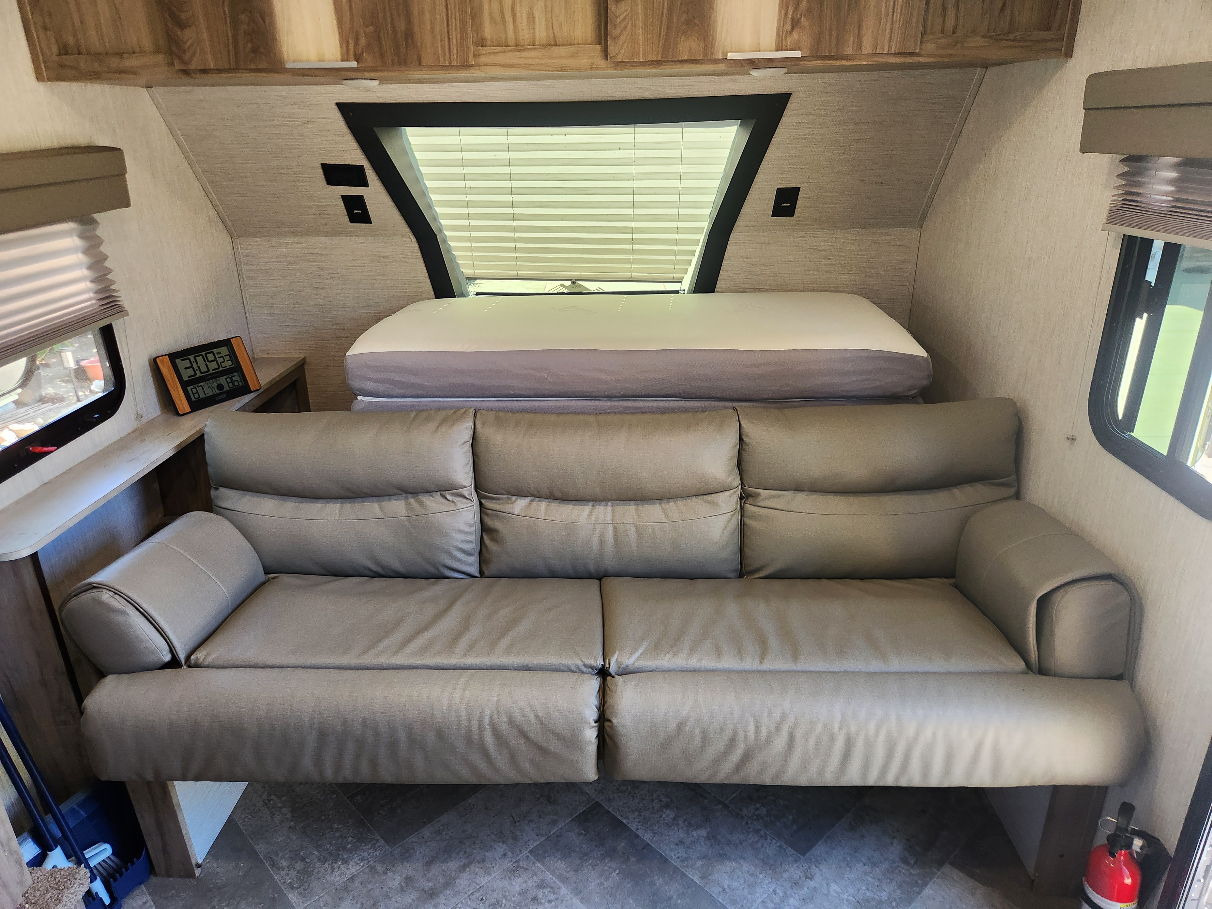 RV rental interior: A spacious living area with a large sofa, comfortable bed, and ample natural light from windows.. Palomino Real Lite Mini 2022