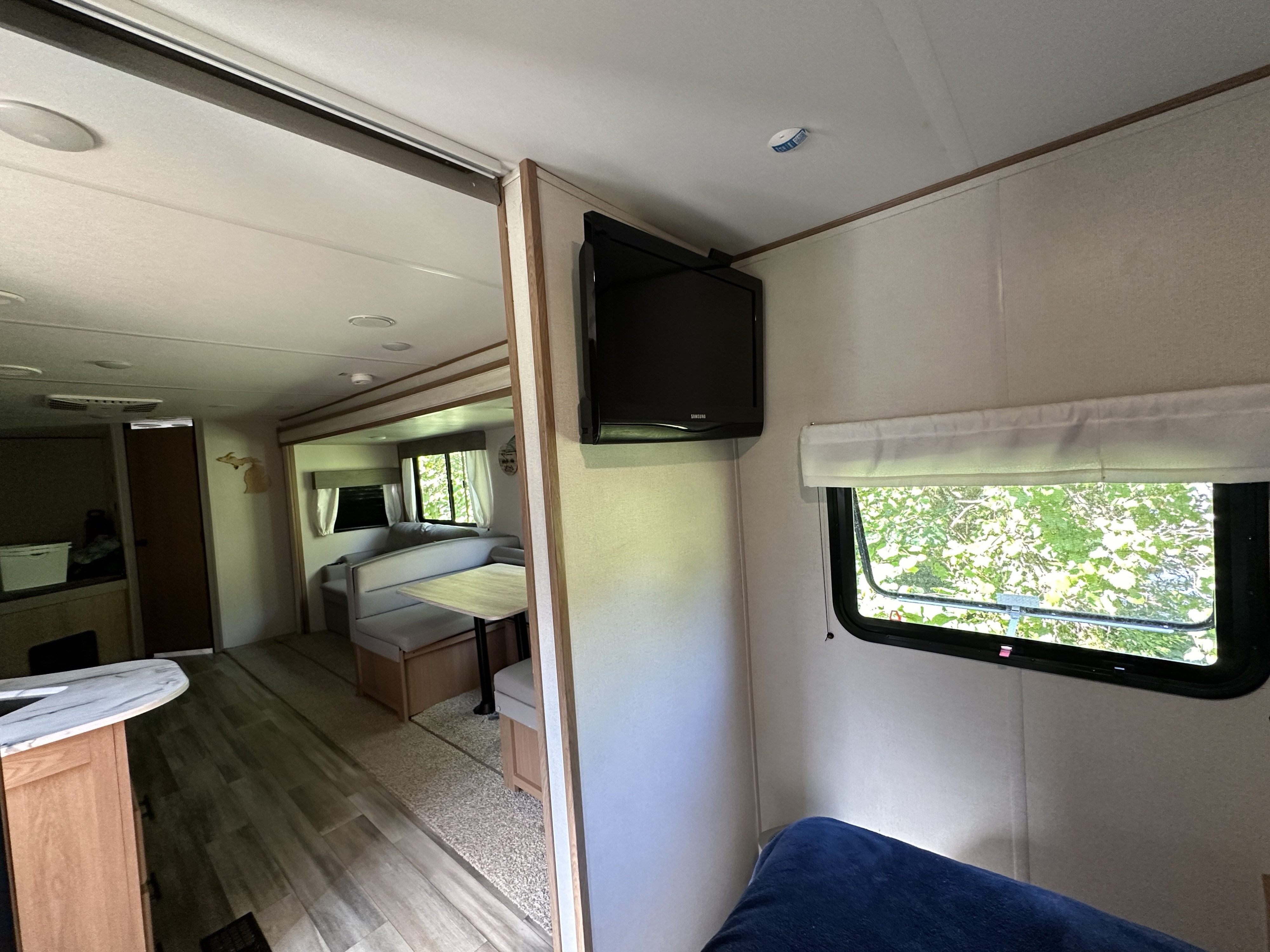 Spacious RV rental interior featuring a bright dinette area, wall-mounted TV, and cozy sleeping space for your next camper adventure.. Avenger Avenger Trailer 2022