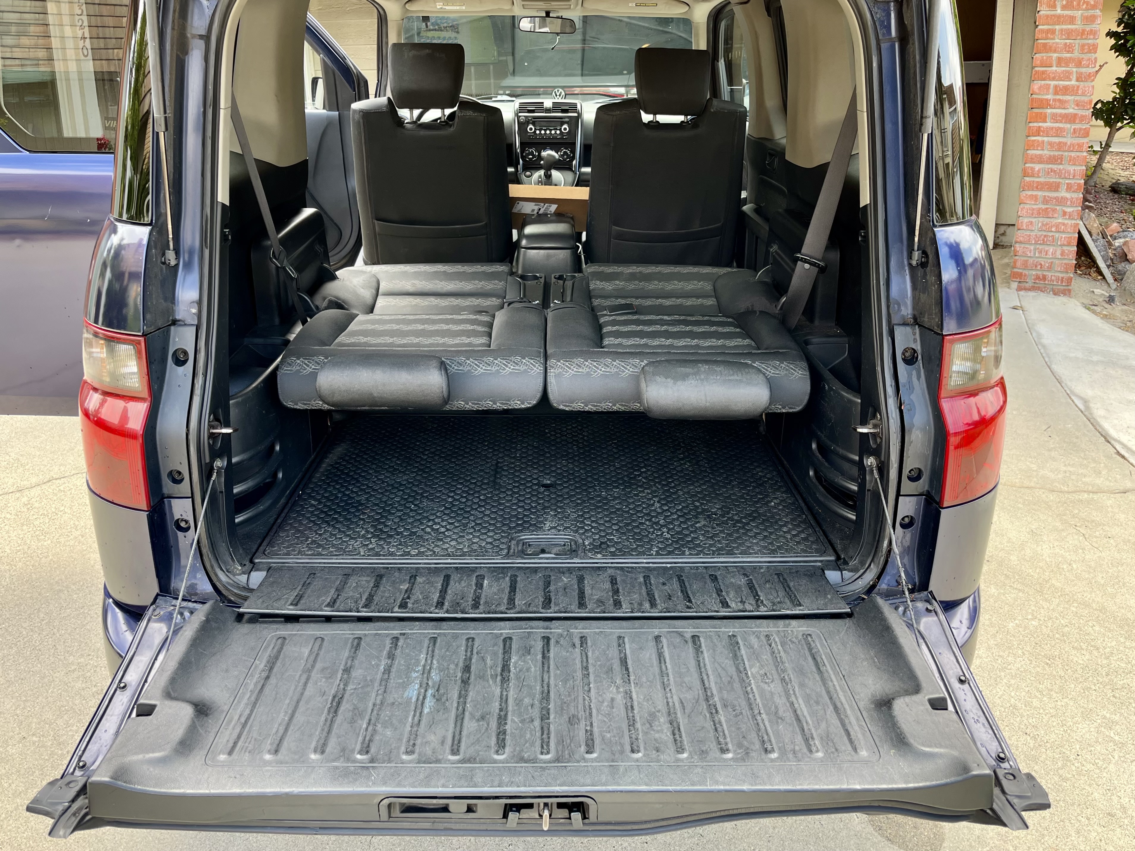 Rear view of a vehicle with open tailgate & stowed seats, creating vast cargo space. Ideal for adventures like an rv rental.. Honda Element 2008
