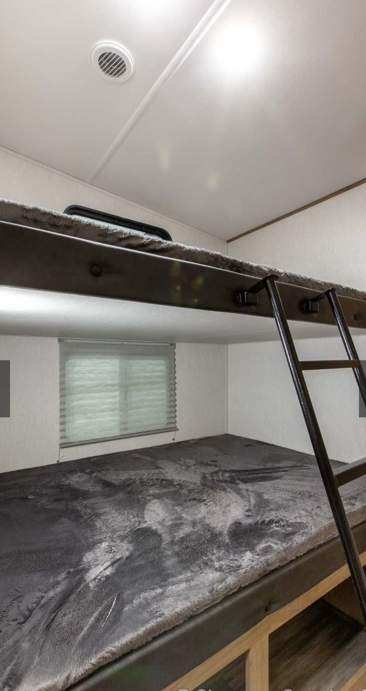RV rental interior features cozy bunk beds with fuzzy blankets & a ladder. Perfect compact sleeping for your adventures.. Forest River Cherokee Arctic Wolf 2023