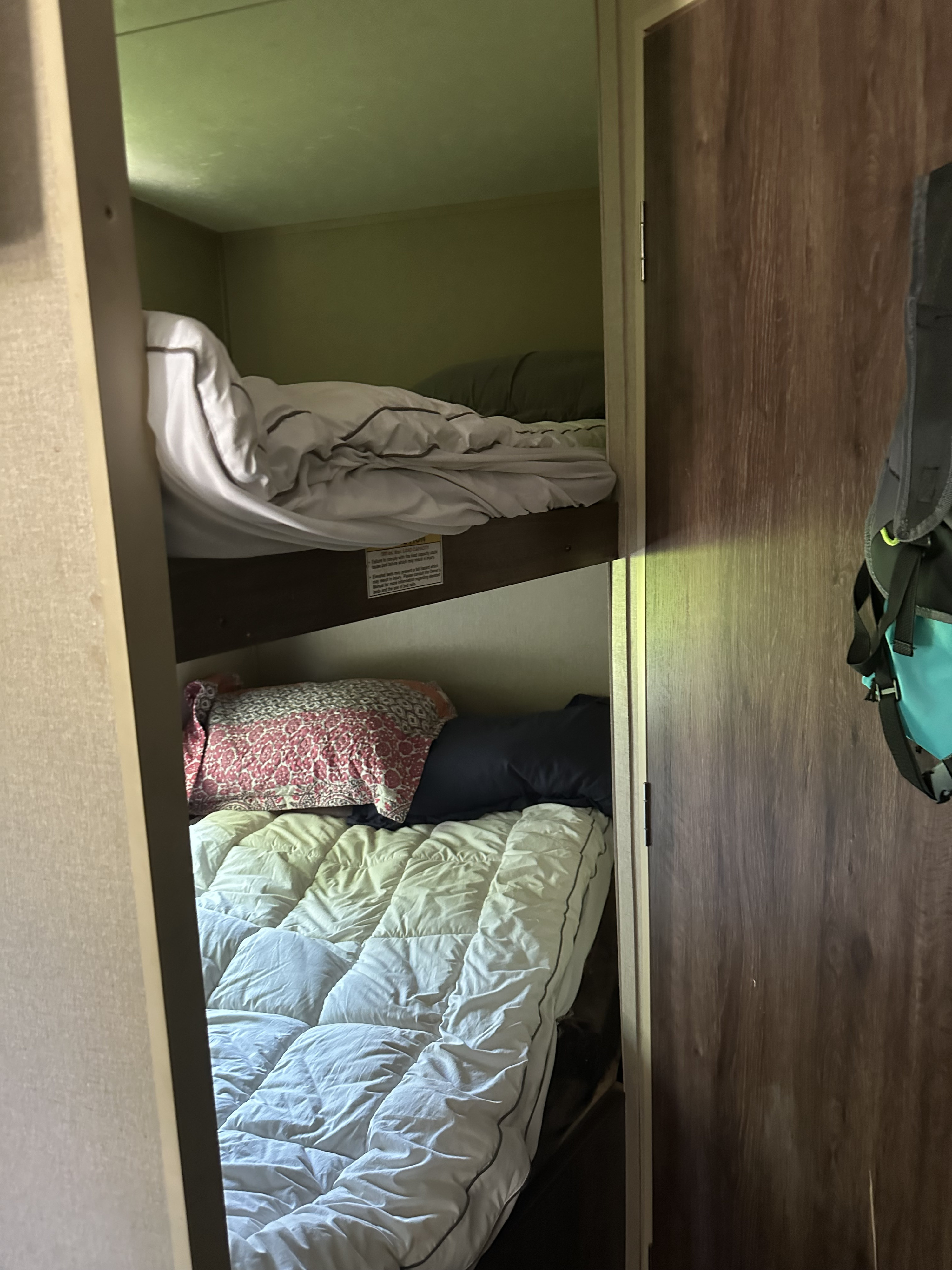 Inside this RV rental, stacked bunk beds display pillows and bedding, providing compact sleeping accommodations.. Dutchmen Coleman Lantern 2015