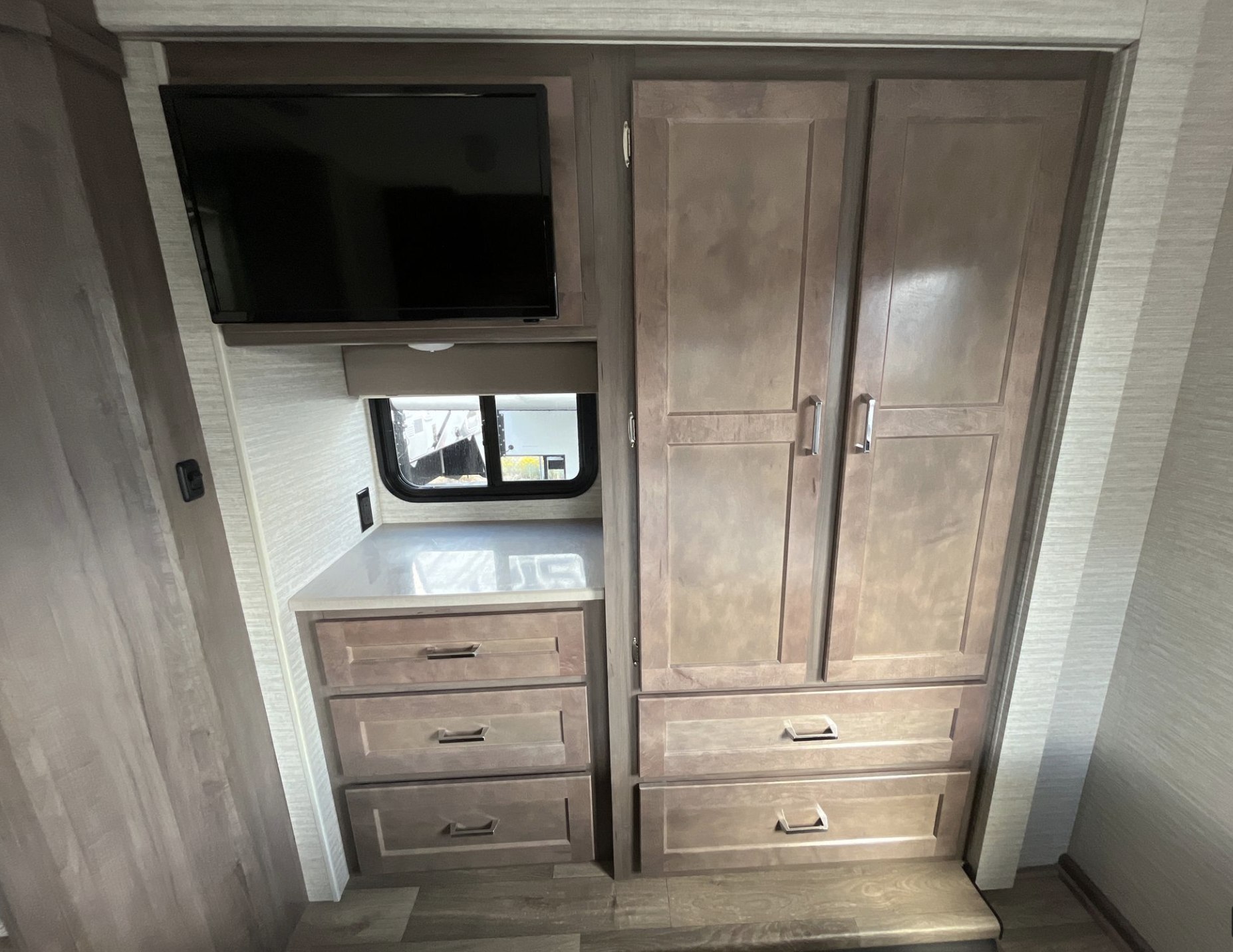 Inside this **rv rental**: a wall-mounted TV, ample storage with built-in wardrobe and drawers, plus a window.. Winnebago Minnie Winnie 2022