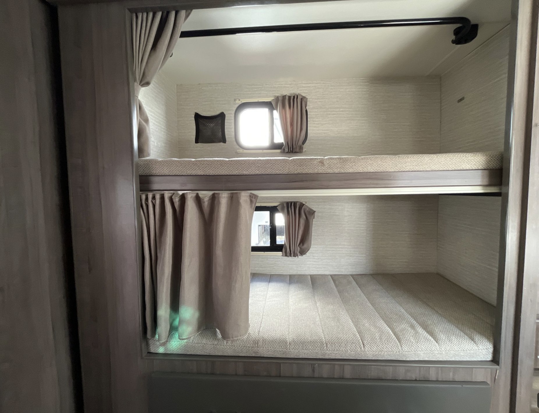 RV rental bunk beds: A cozy sleeping area with stacked beds, mattresses, and windows.. Winnebago Minnie Winnie 2022