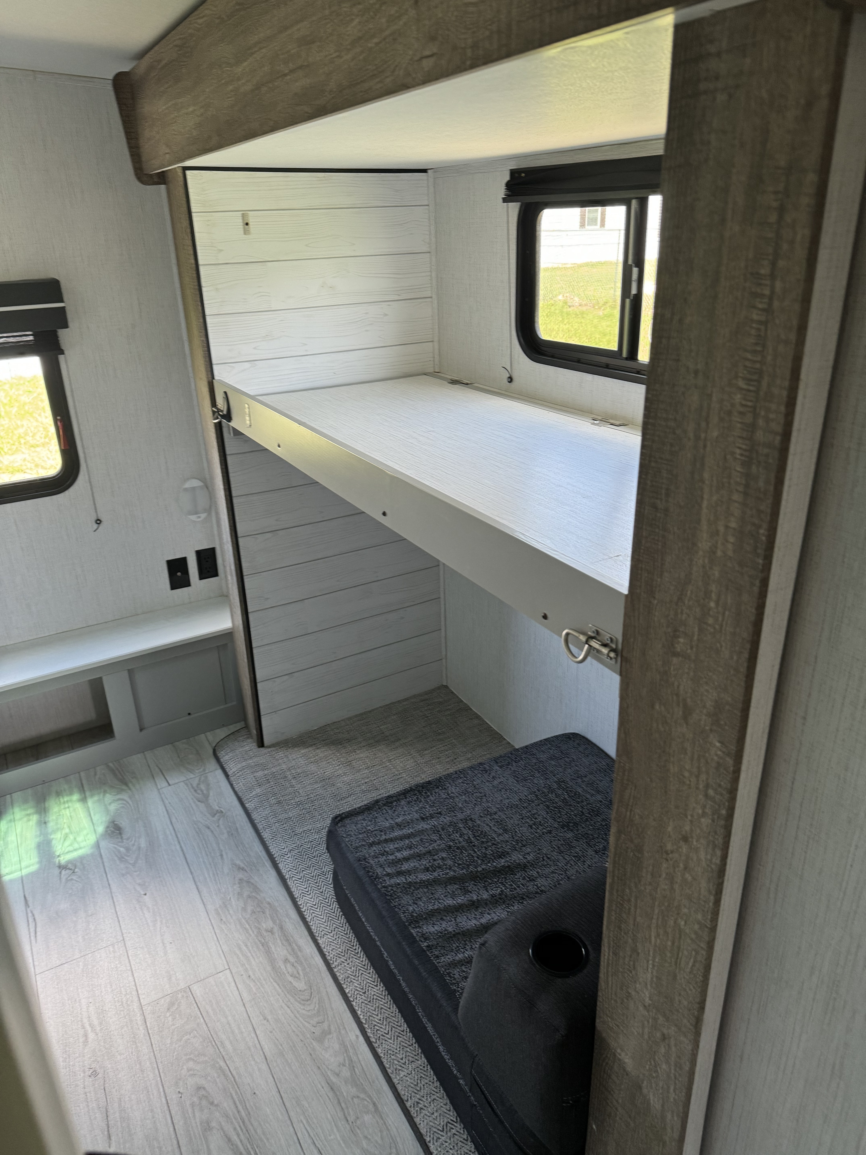 RV rental: Bright interior bunk area with light wood finishes, lower padded bed, and windows for compact travel comfort.. Heartland RVs North Trail 2022