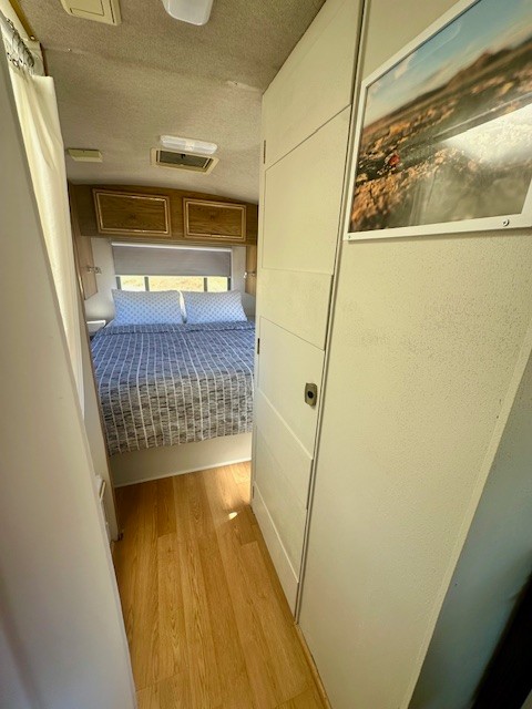 Inviting RV rental interior. Hallway leads to a cozy bedroom with a patterned bed & storage. Bright, clean space.. Flair-Fleetwood Flair-Fleetwood Motorhome 2002