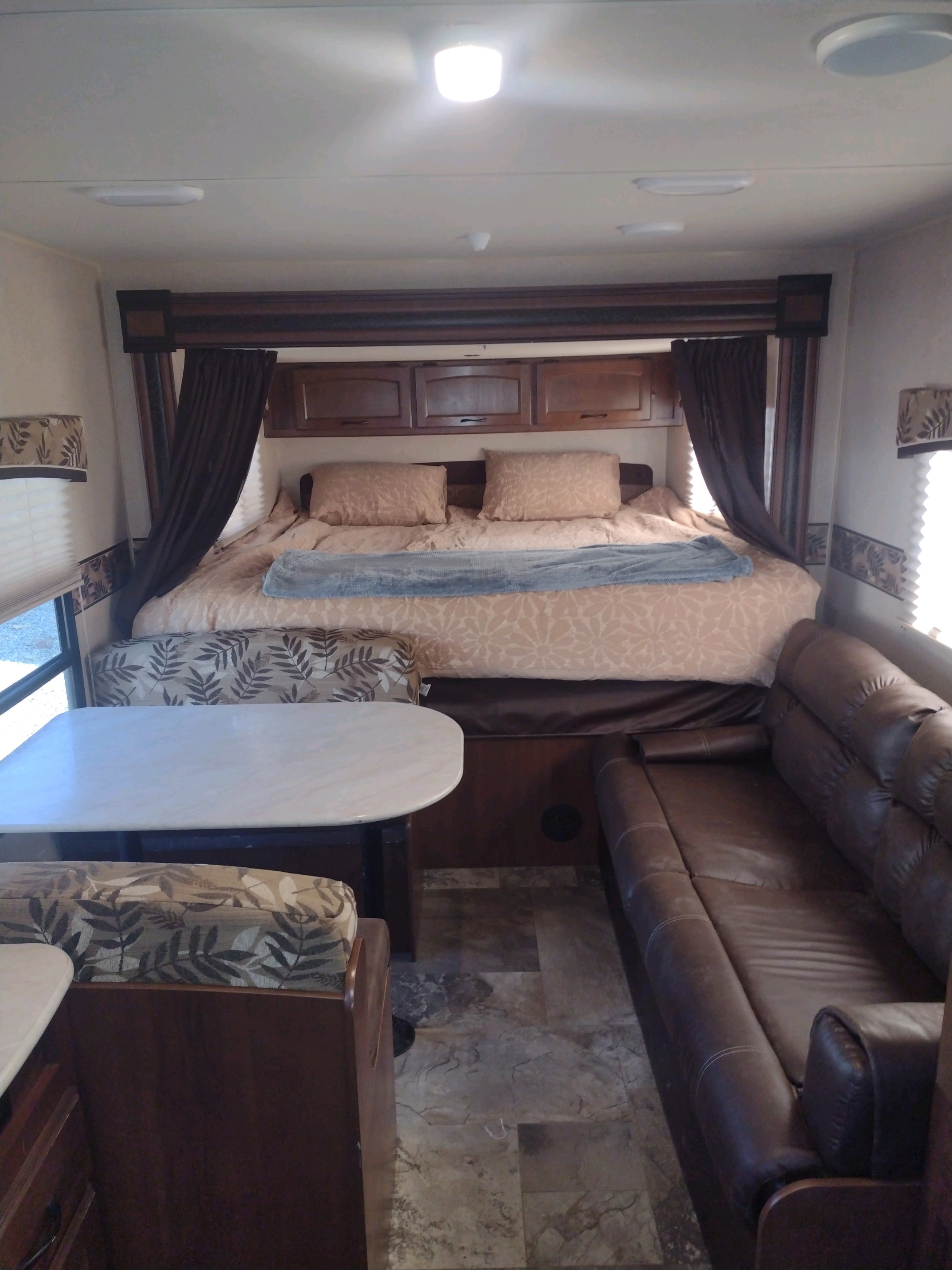 Cozy RV rental interior featuring a large bed, dinette with table, and comfortable sofa.. Jayco Jay Feather Ultra Lite 2015