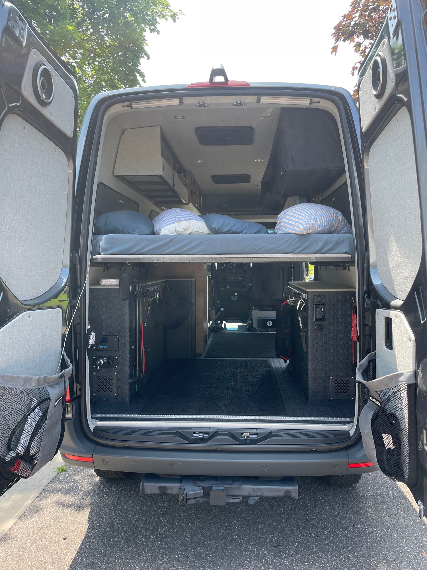 Inside an rv rental camper van: elevated bed, organized storage, and utility panels create a functional custom build for adventures.. Mercedes 2500 van 2022