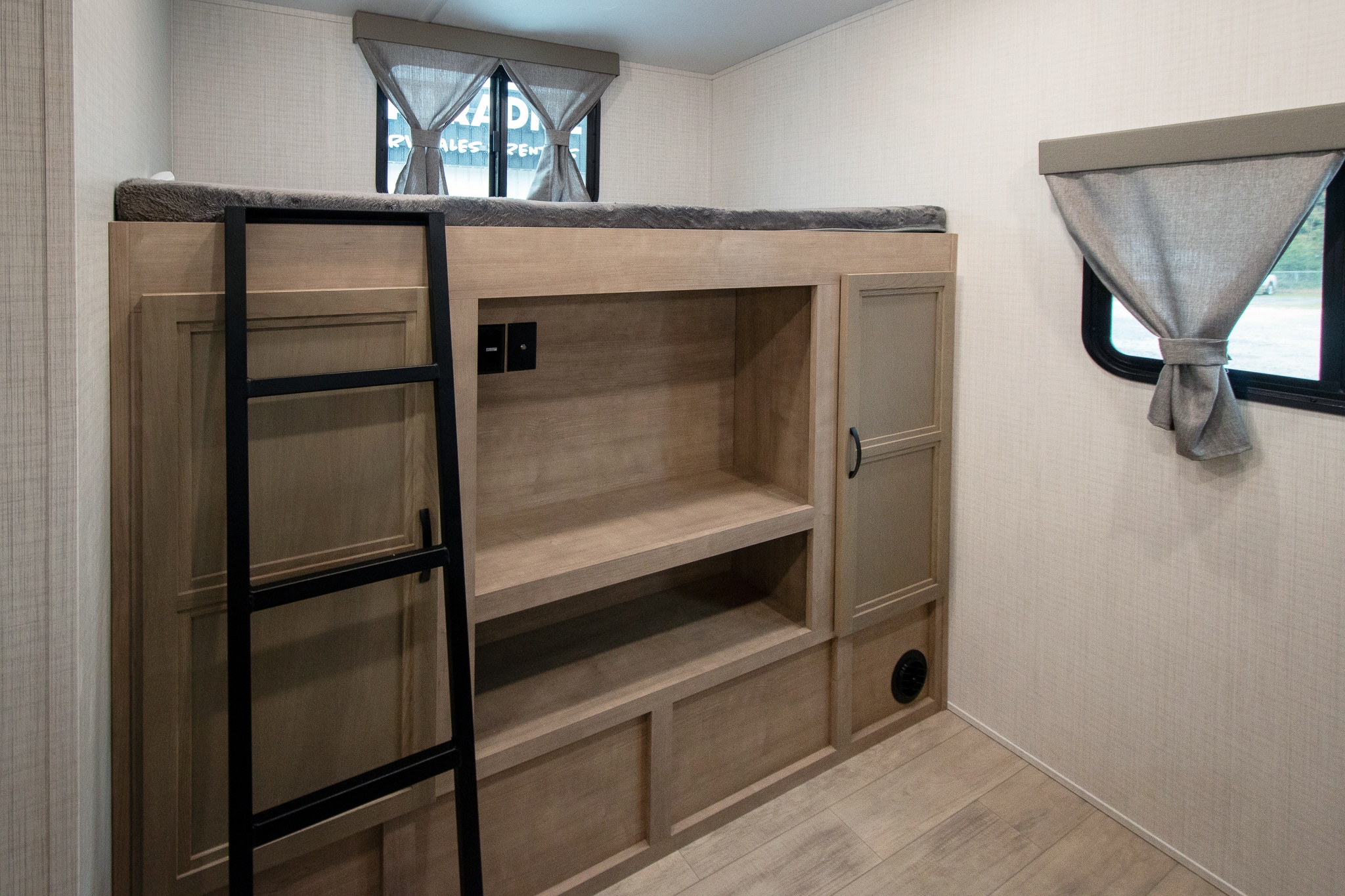 This RV rental offers a cozy bunk bed with ladder, built-in storage, and shelves, optimizing compact living space.. Palomino Solaire Ultra Lite 2024