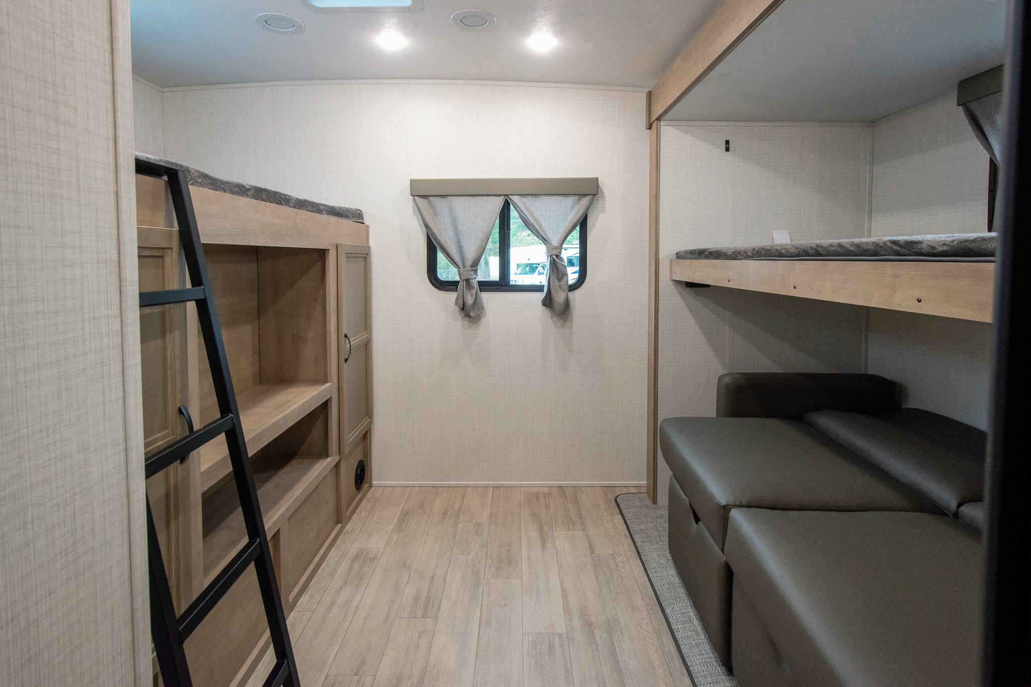RV rental interior featuring bunk beds, a ladder, a window, and a convertible sofa, ideal for travel.. Palomino Solaire Ultra Lite 2024