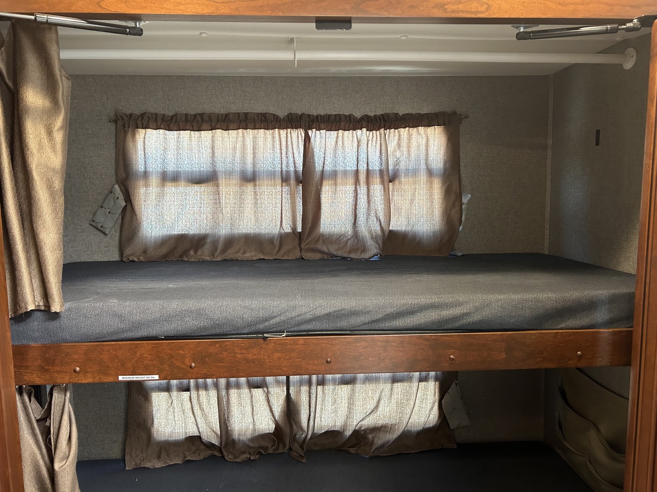 Cozy RV rental sleeping area featuring comfortable bunk beds with curtains, perfect for families.. Forest River Berkshire 2023