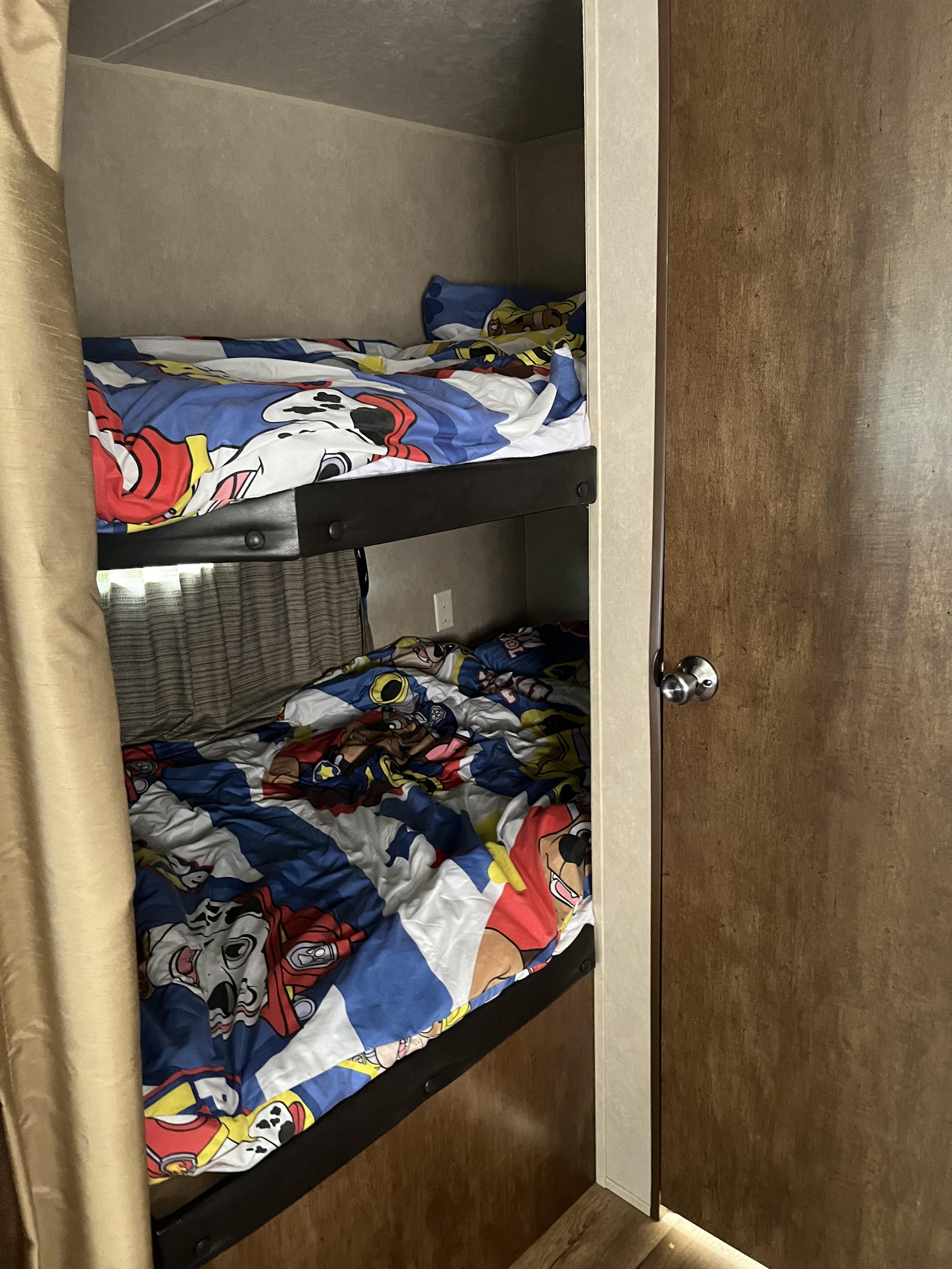 Compact bunk beds in an RV rental, featuring colorful Paw Patrol bedding, perfect for a kids' adventure sleep space.. Forest River Salem 2017
