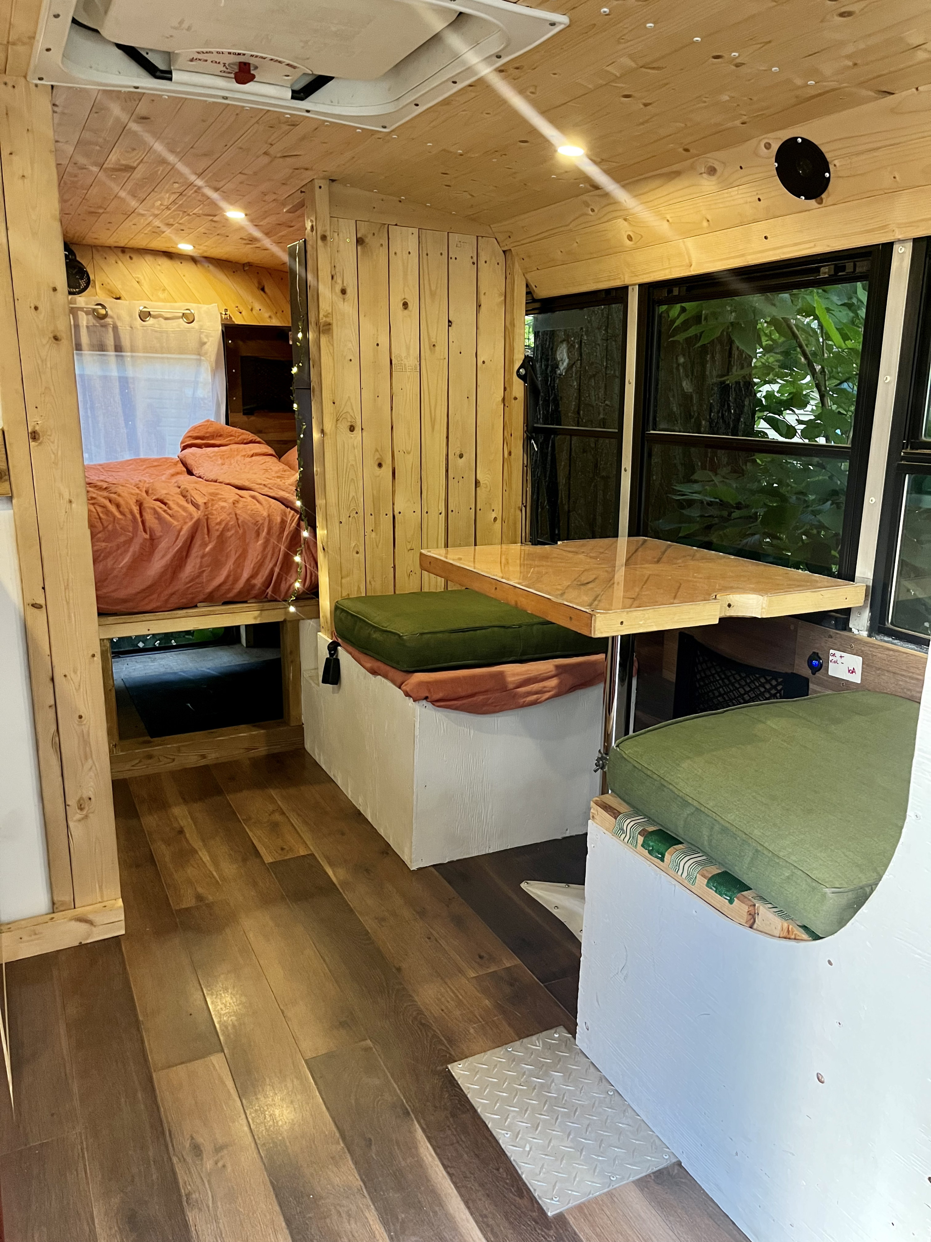 This RV rental features a compact, wood-paneled interior with a built-in bed and dining booth.. Chevrolet Express 3500 2009