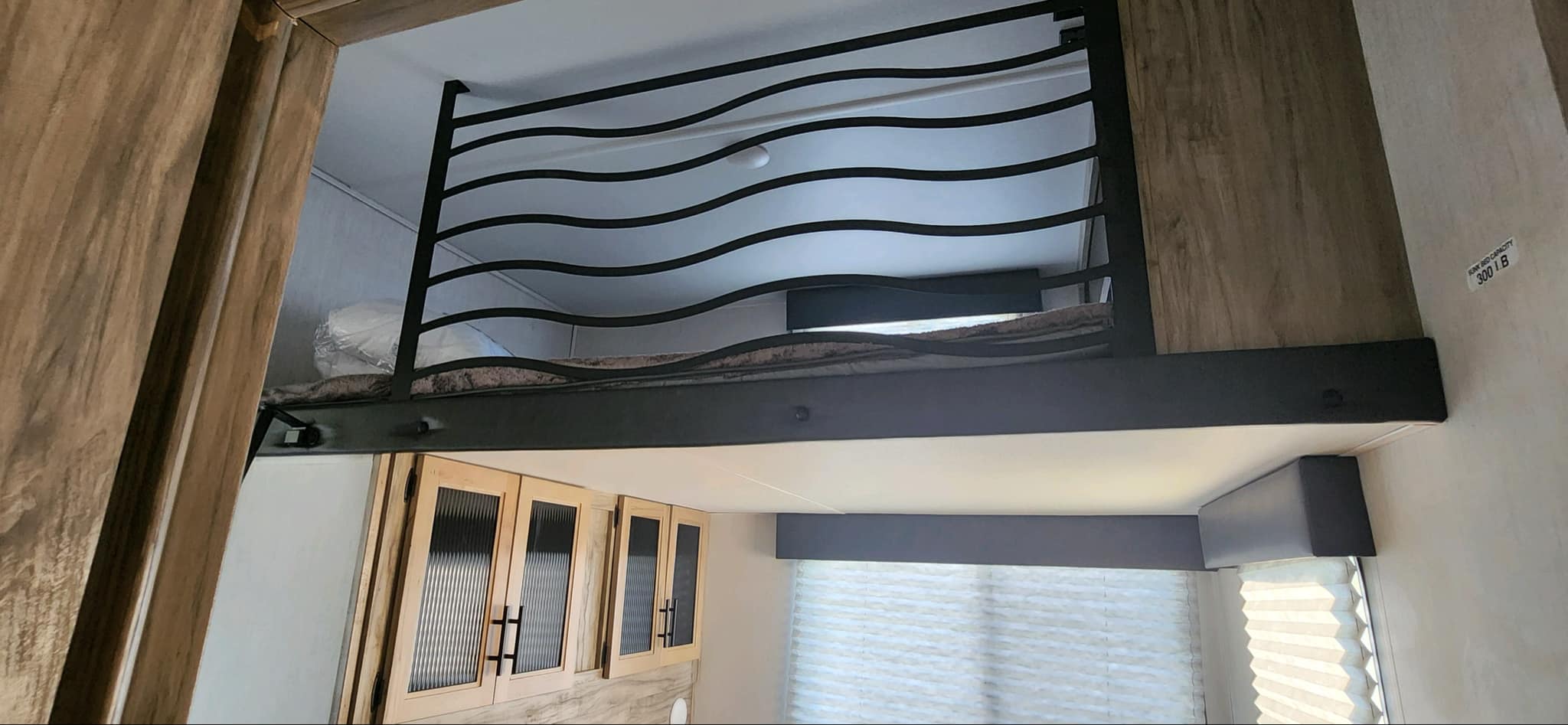 Comfortable RV rental bunk bed setup with stylish wavy safety railing, perfect for family travel. 300 lb capacity.. Forest River Cherokee Arctic Wolf 2021