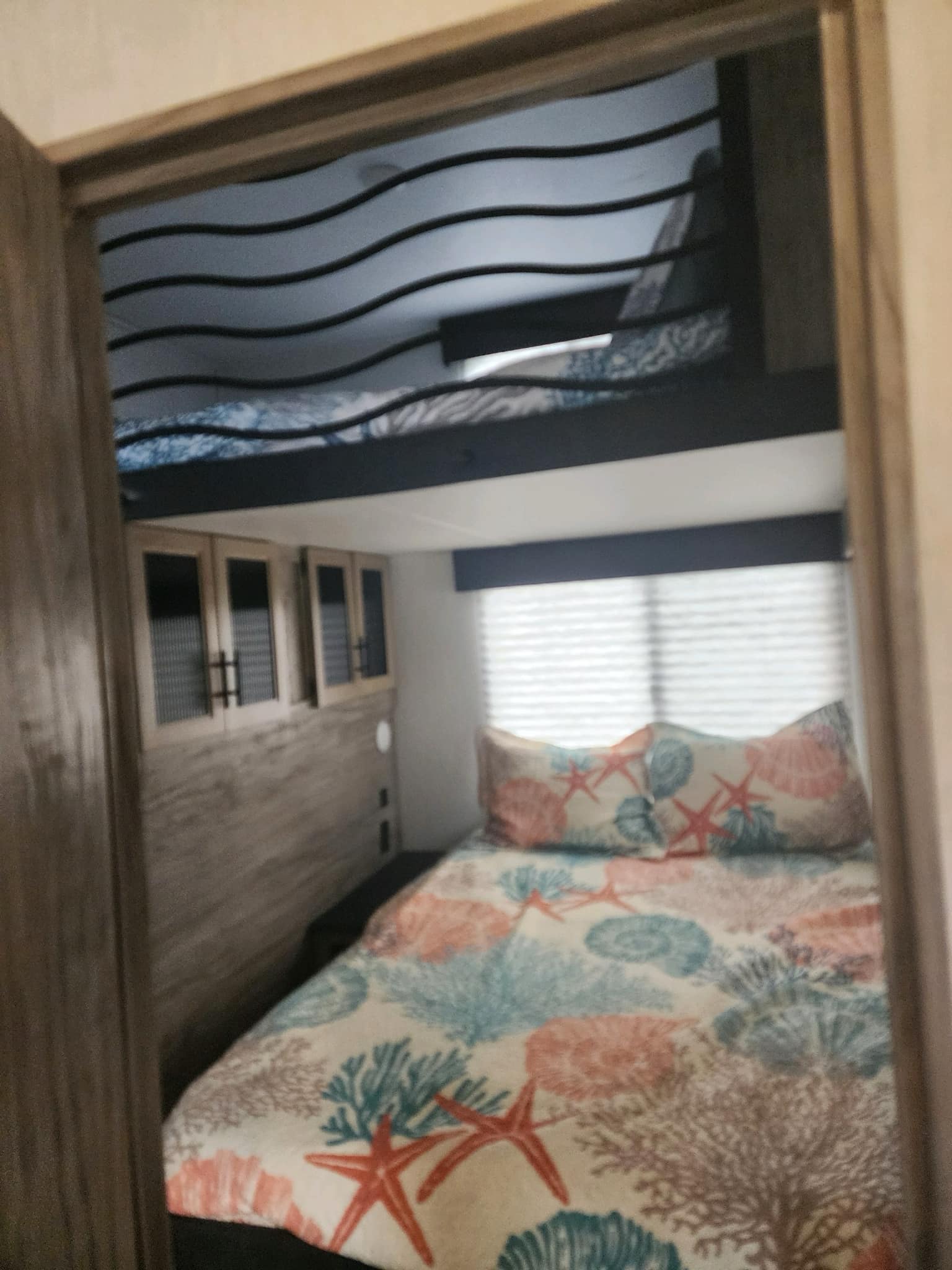 Enjoy a cozy RV rental bunkhouse with coral bedding. Perfect for family travel & camping.. Forest River Cherokee Arctic Wolf 2021