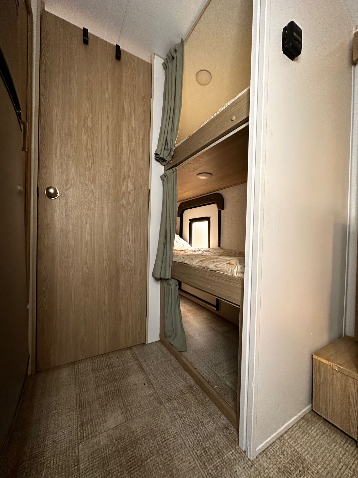 Cozy RV rental bedroom featuring bunk beds with privacy curtains and a closed door.. Forest River Rockwood Geo Pro 2021