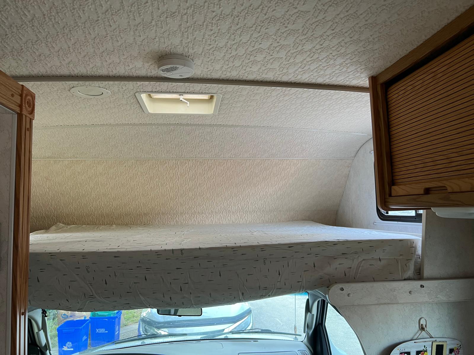 RV rental: The cab-over bunk bed, complete with mattress, textured ceiling, vent, and smoke detector, provides overhead sleeping.. Itasca Spirit 2003