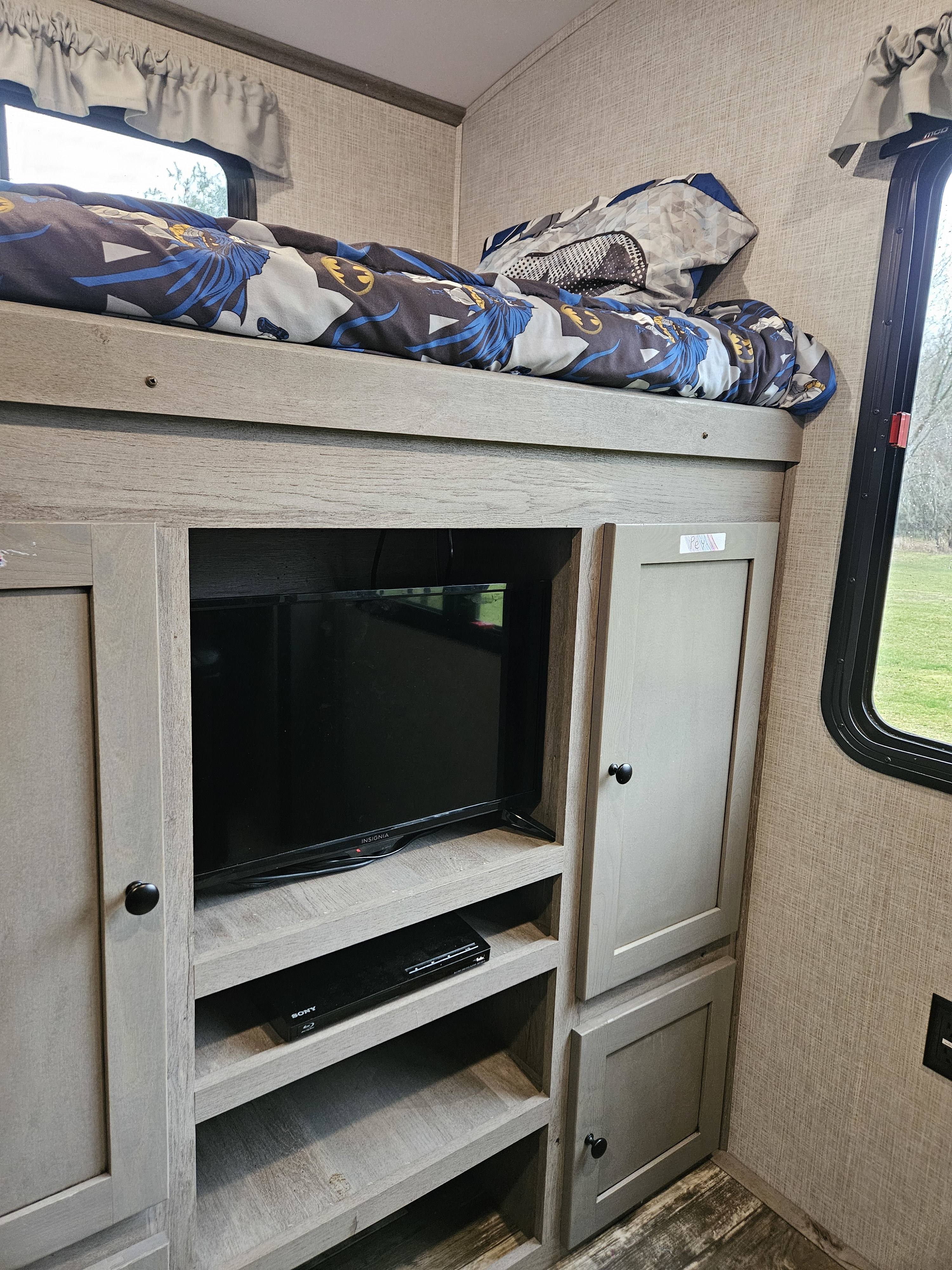RV rental interior featuring bunk beds, a TV with a Sony player, and storage cabinets.. Keystone Outback 2020