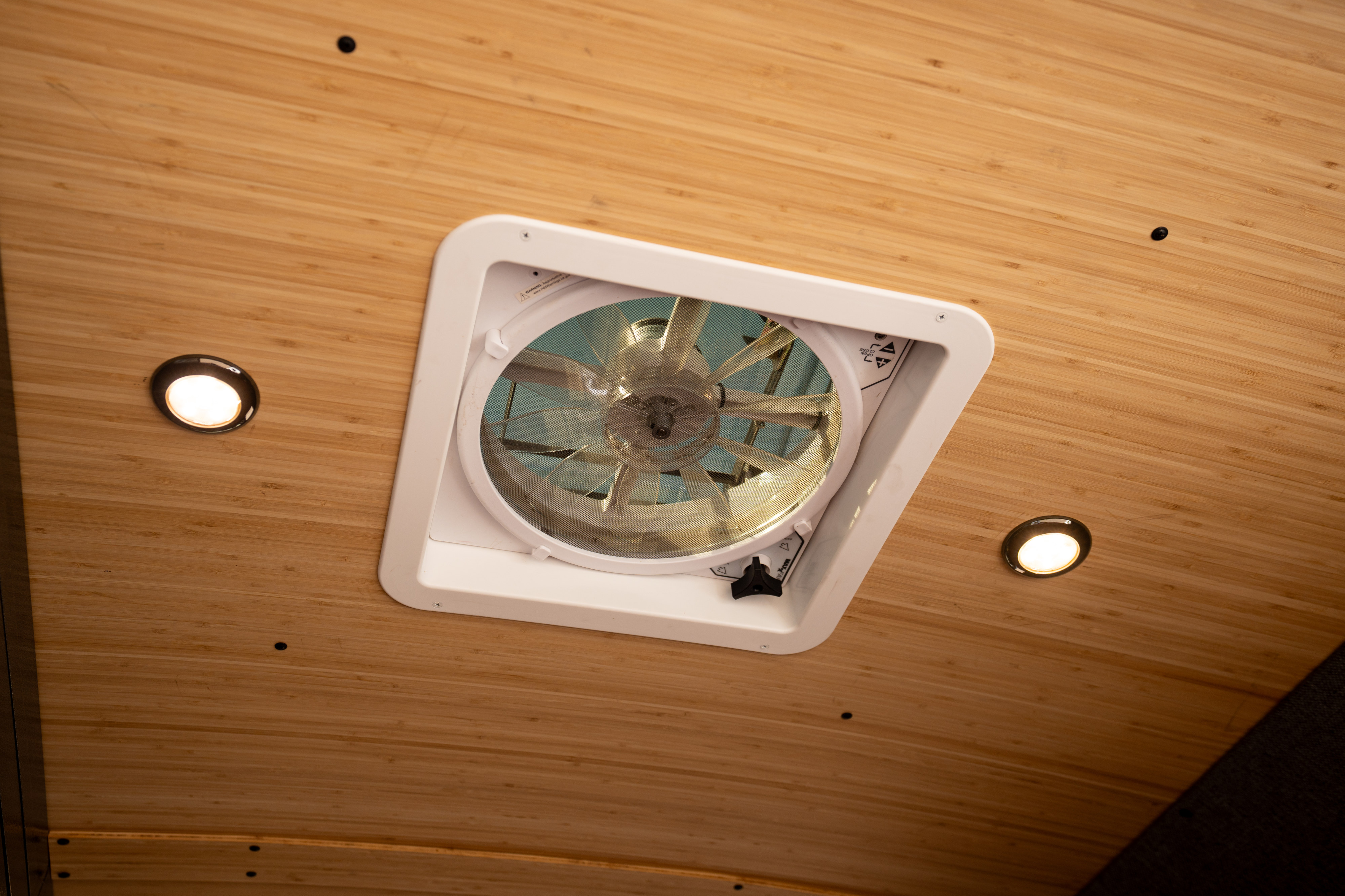 RV rental interior ceiling with a central fan, two bright recessed lights, and warm wood paneling.. Mercedes-Benz Sprinter 2024