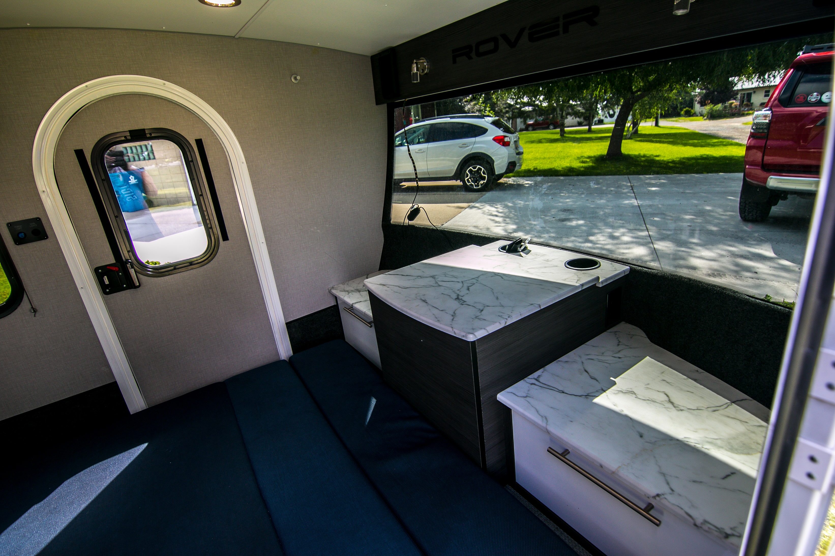 Explore this compact **RV rental** interior with a cozy sleeping area, marble-top dining table, and scenic view from the large window.. InTech RV Luna 2022