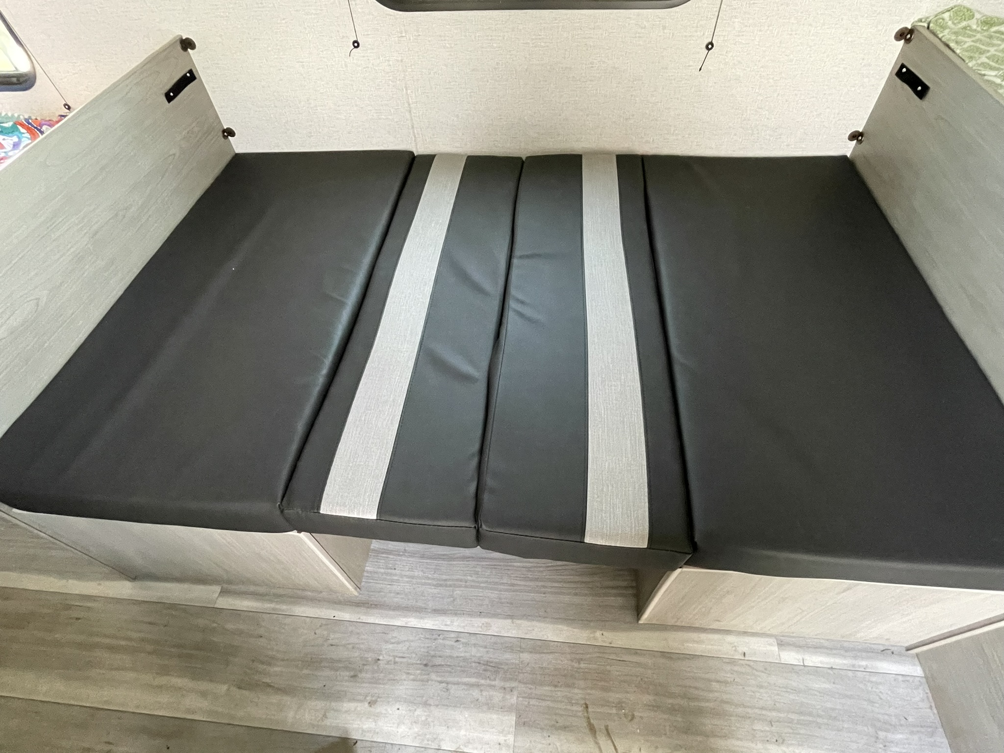 RV rental interior: versatile black & grey cushioned dinette/bed area.. Keystone RV Springdale 2024
