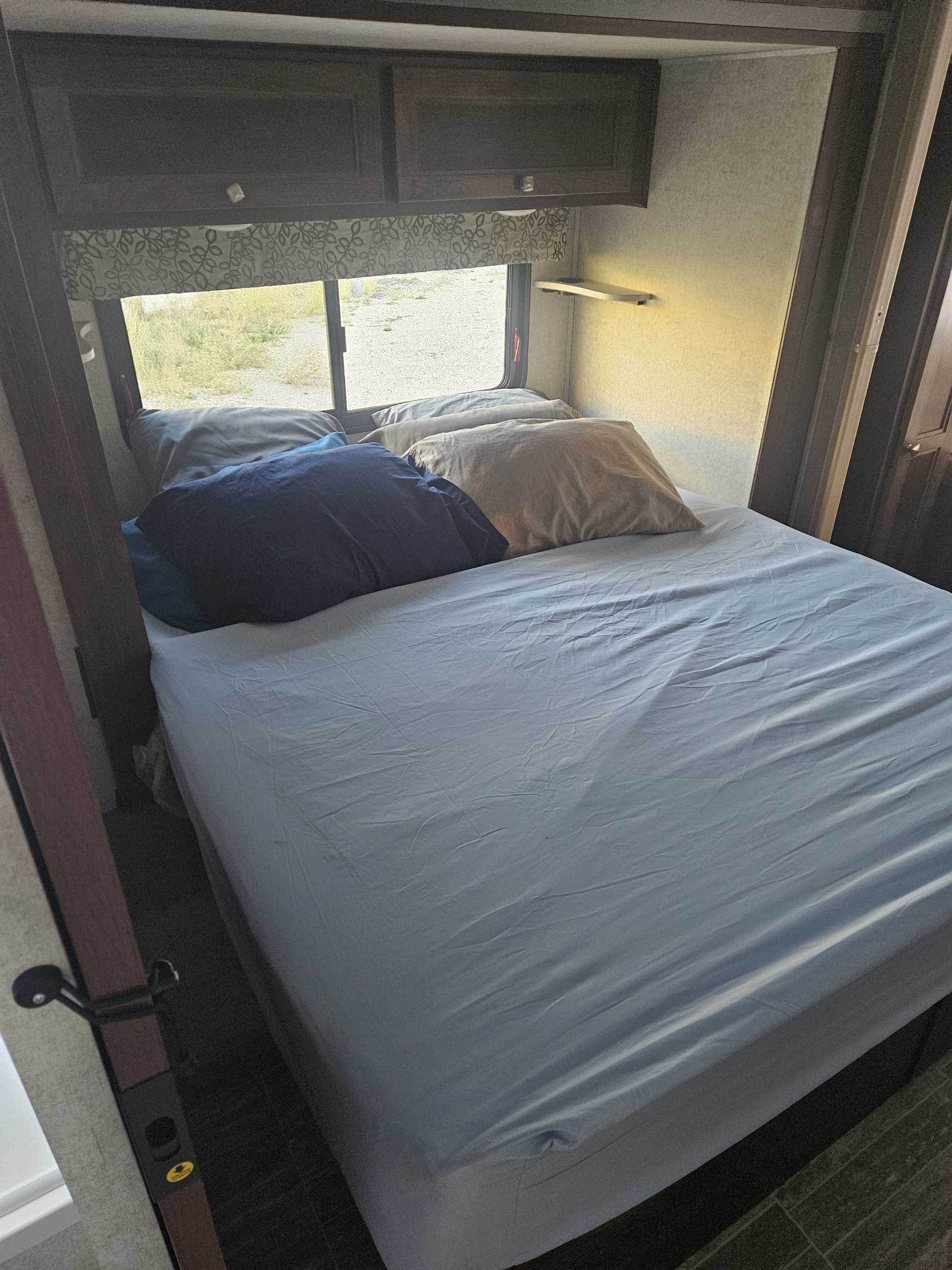 Comfortable RV rental bedroom with light blue sheets, pillows, and overhead cabinets for a cozy night's sleep.. Forester Forester Motorhome 2020