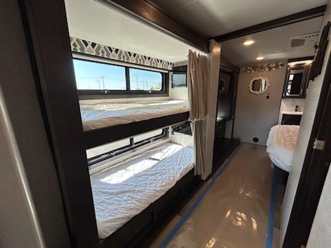Spacious RV rental interior with bunk beds, master bed, and bathroom area, ideal for family adventures.. Entegra Coach Vision XL 2022