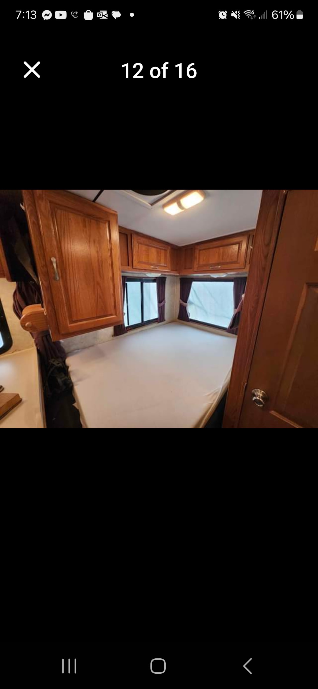 RV rental bedroom with a clean mattress, wooden overhead cabinets, and windows with curtains. Ideal for a comfortable stay.. Four Winds Majestic 2005