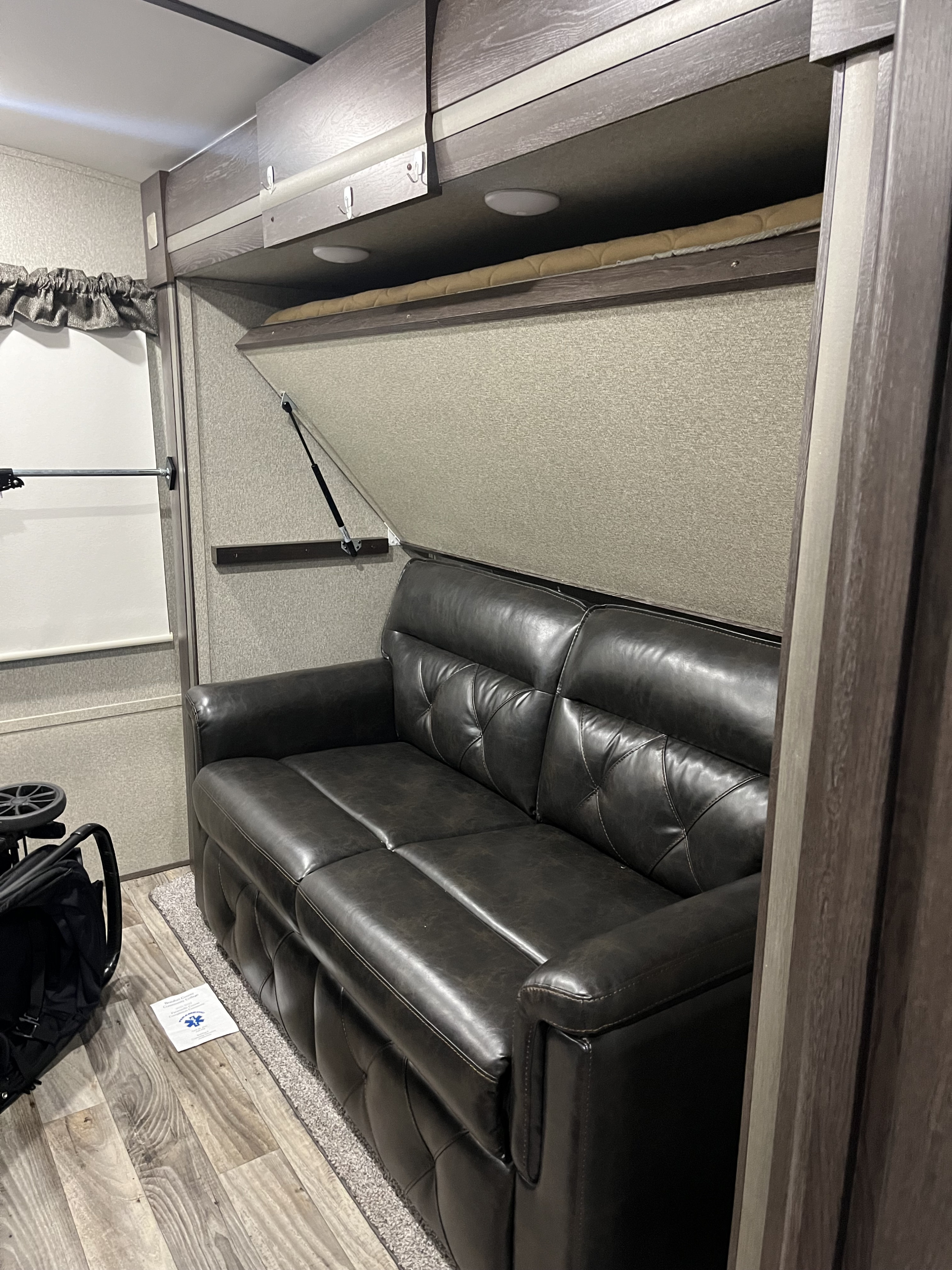 RV rental interior: A dark leather sofa and an overhead convertible bunk bed system optimize this compact living space.. Keystone RV Outback 2019