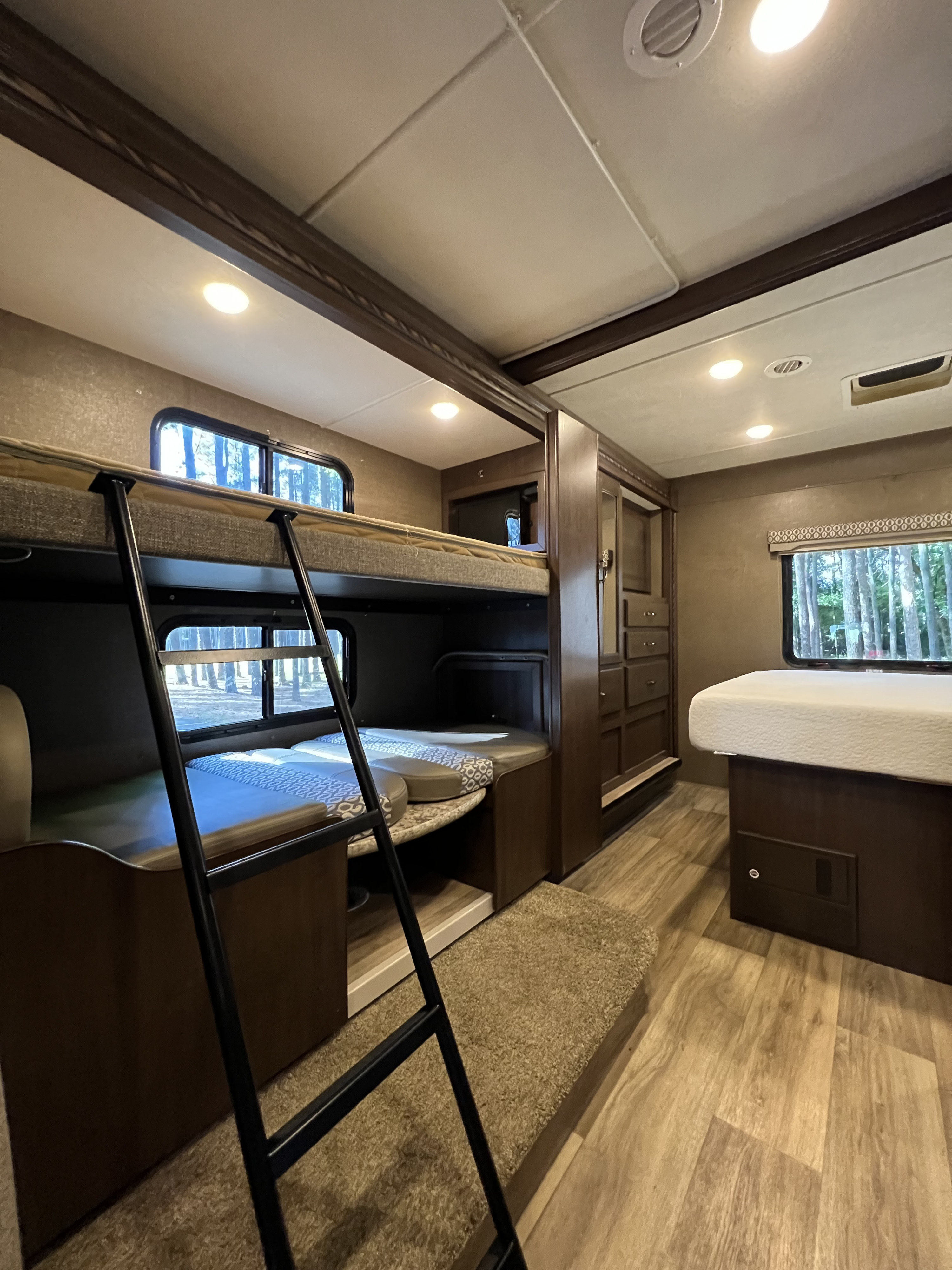 RV rental interior features bunk beds, a convertible dinette, and a main bedroom area, ideal for family trips.. Thor Freedom Elite 2018