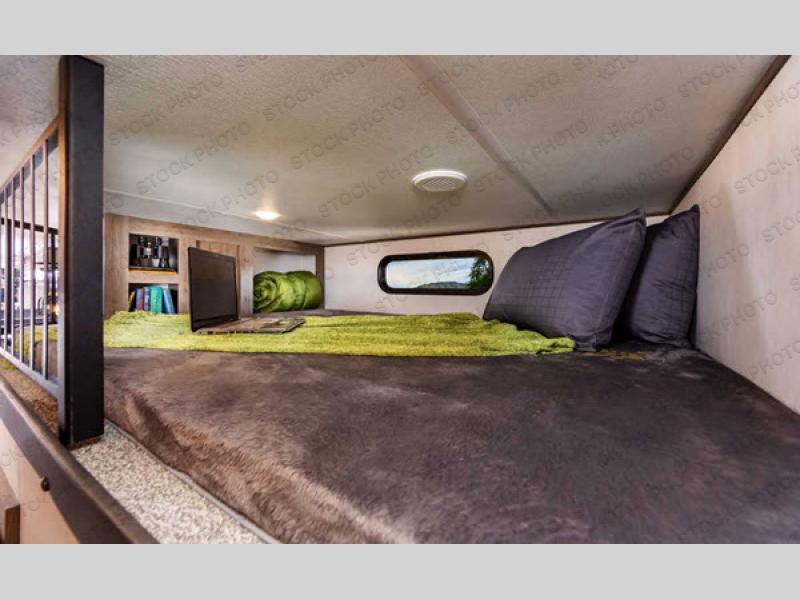 RV rental: Cozy cabover bunk features a bed, TV, storage, and a window with a scenic view, perfect for travel.. Forest River Sabre 2021